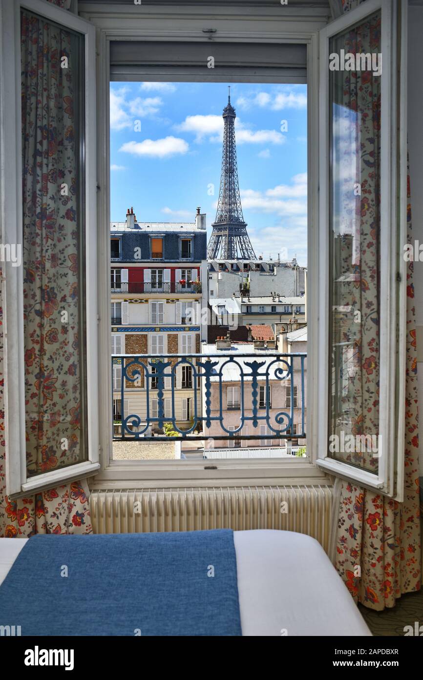 Una camera d'hotel a Parigi con vista sulla Torre Eiffel dall'hotel, Les Jardins d'Eiffel, tetti, nuvole bianche del cielo blu. Foto Stock