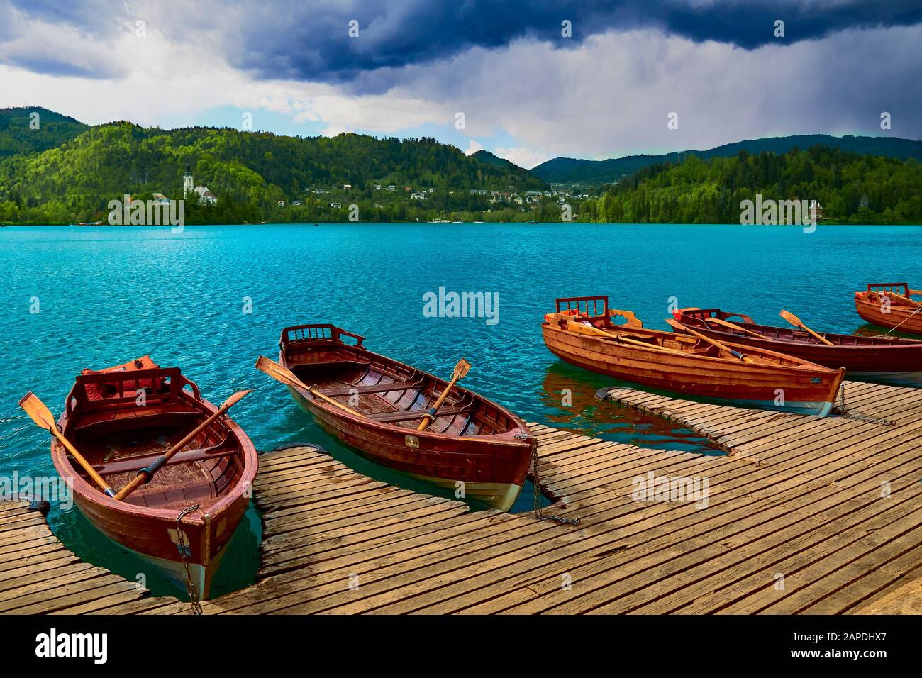 Barche in banchine sul lago di Bled, prima della pioggia Foto Stock