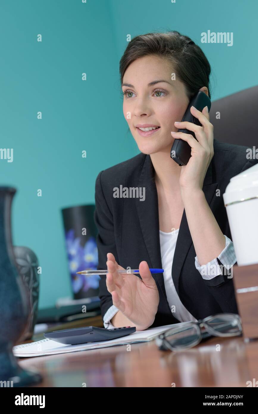 Donna con telefono in ufficio Foto Stock