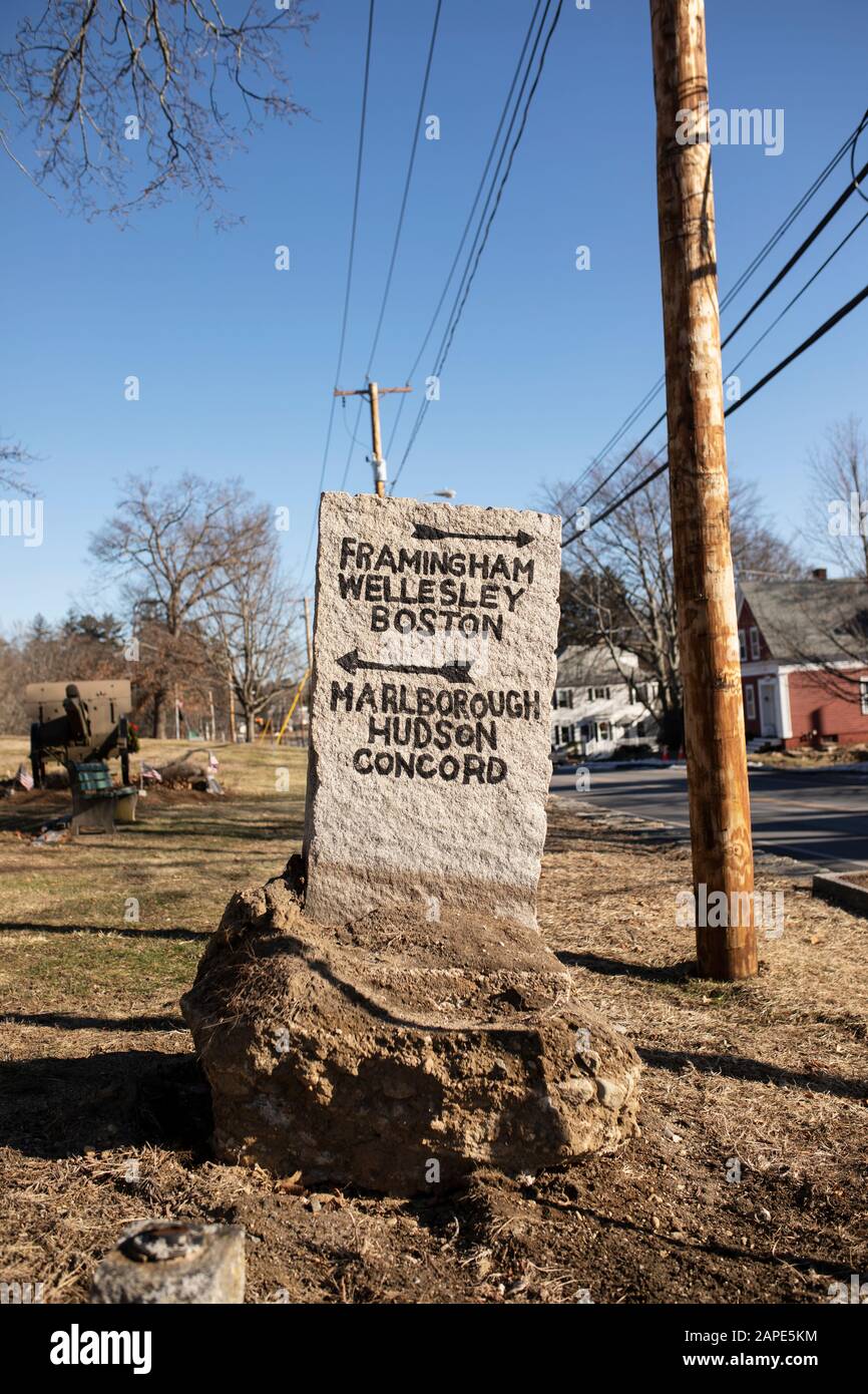 Un cartello direzionale in pietra con frecce che indicano Boston e altre città al di fuori di Main Street nel centro di Southborough, Massachusetts, Stati Uniti. Foto Stock