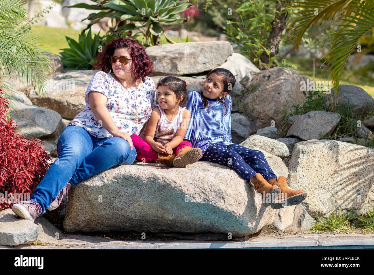 Famiglia carina di madre e figlie nel giardino Foto Stock