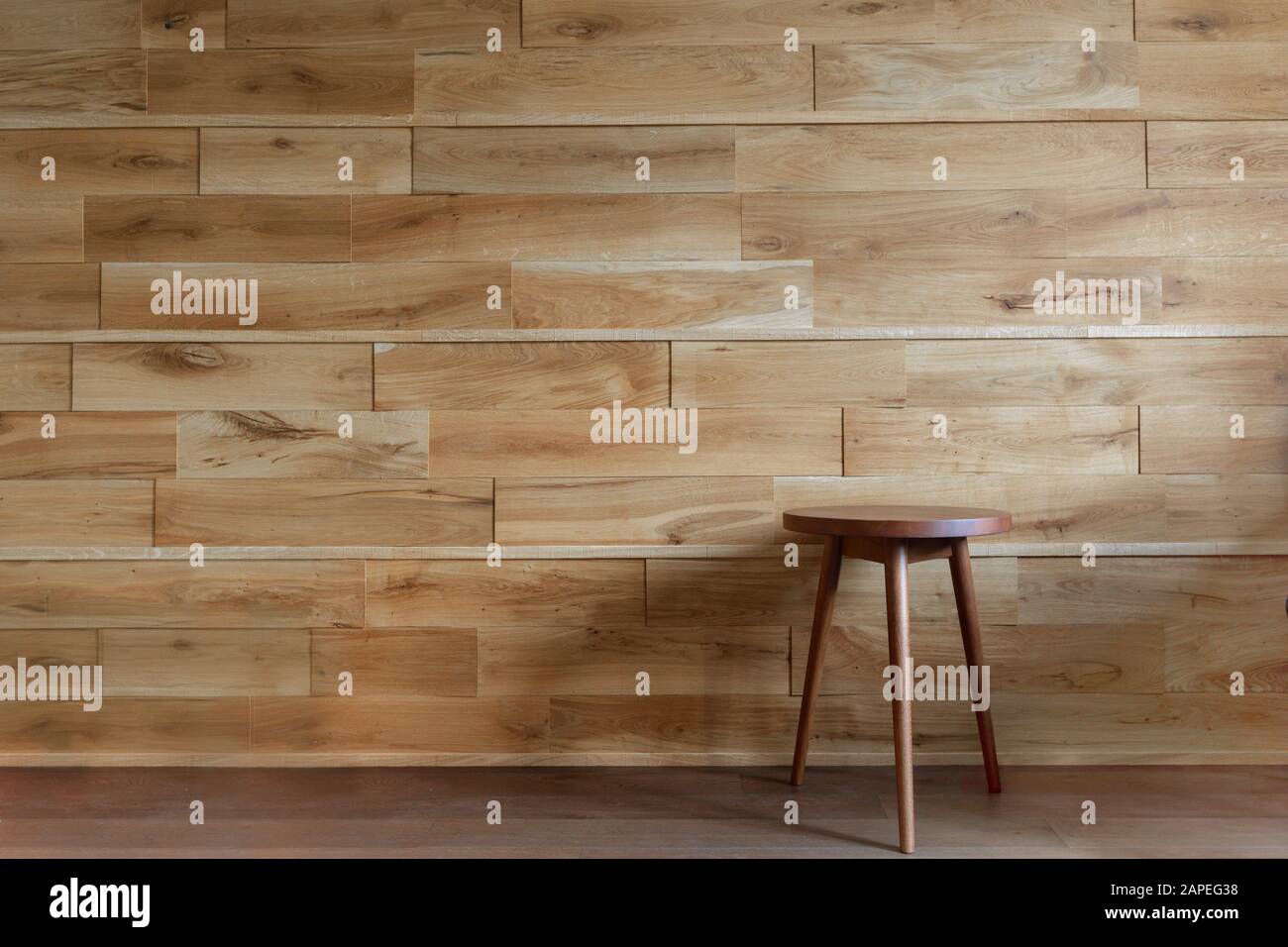 Sedia rotonda accanto a parete di legno Foto Stock