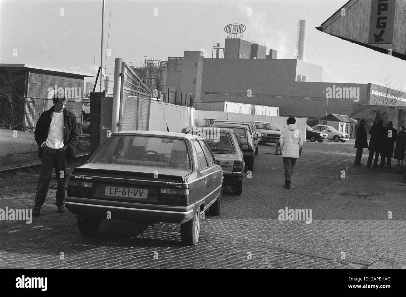 Bestoved automobili in attesa di un lavaggio libero dopo che sono stati contaminati dalla società chimica Dupont (sfondo) (Dordrecht) Data: 12 febbraio 1986 luogo: Dordrecht, Zuid-Holland Parole Chiave: Automobili, industria chimica, fabbriche Foto Stock