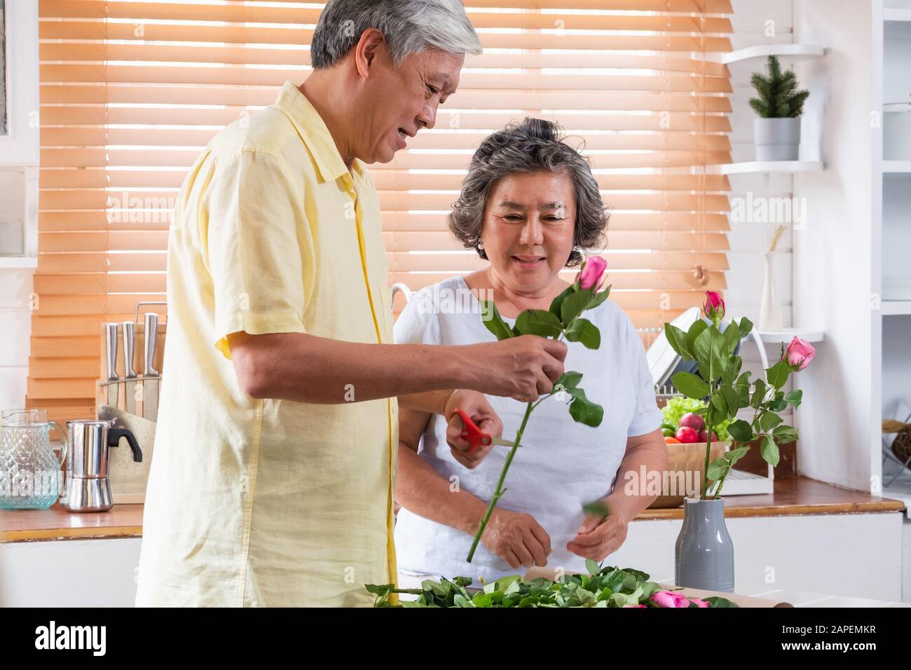 Asian Senior giovane marito e moglie floreale al vaso sulla tavola in cucina a casa nel giorno di San Valentino.bella coppia senior concept Foto Stock
