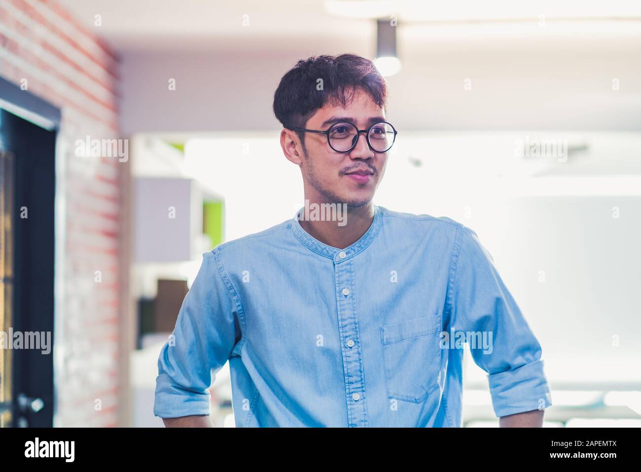 ritratto di designer creativi asiatici levarsi in piedi e sorridere in ufficio moderno Foto Stock