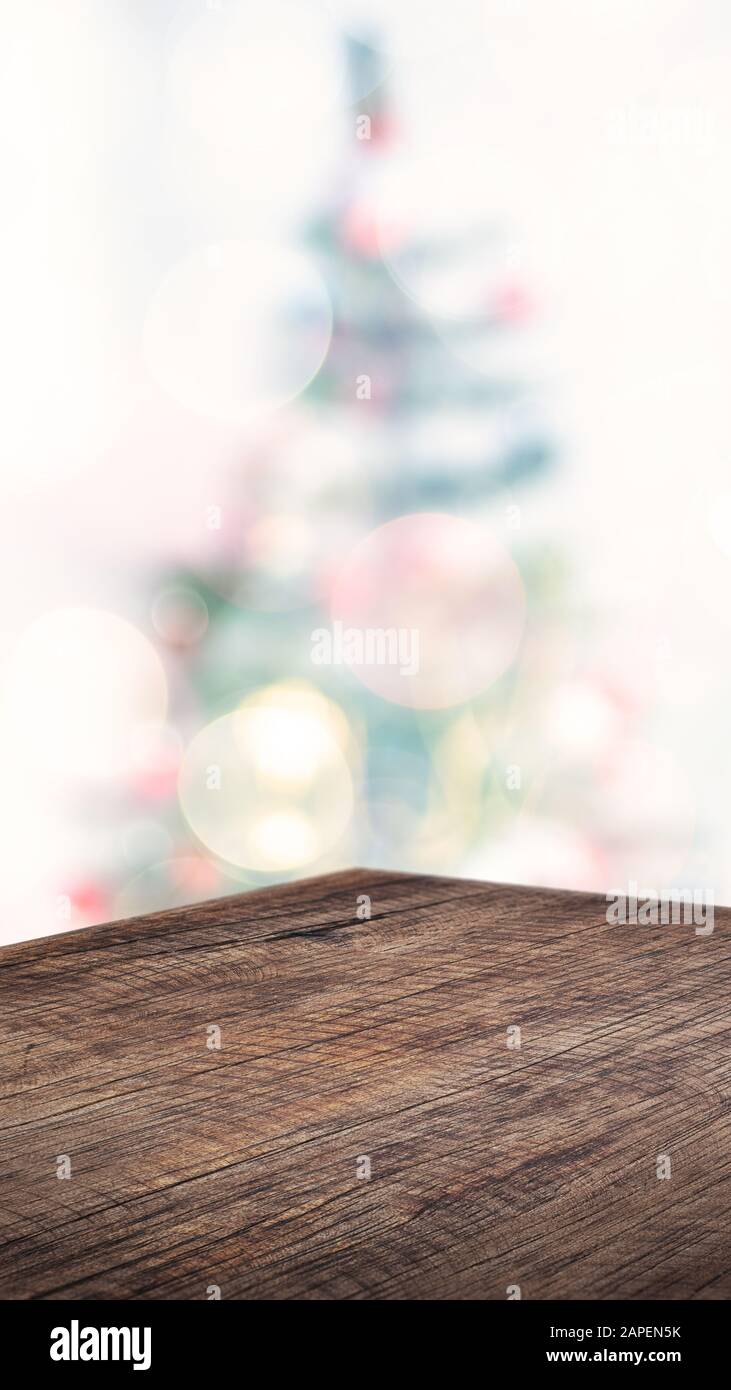 Vuoto angolo marrone tavola di legno con astratto albero di Natale decorazione stringa di sfocatura sfondo chiaro, sfondo vacanza, Mockup banner verticale per la visualizzazione di pr Foto Stock