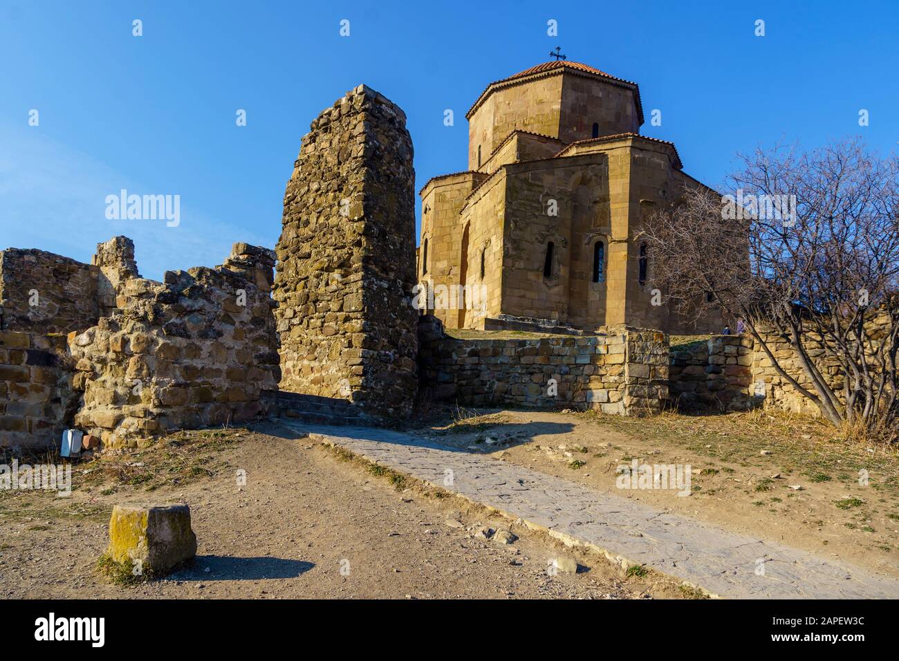 Mtskheta, Georgia. L Antica Chiesa Ortodossa Georgiana Chiesa di Holly Cross, Monastero di Jvari con resti di muro di pietra, Patrimonio Mondiale. Scenografica Blue Nuvoloso Foto Stock