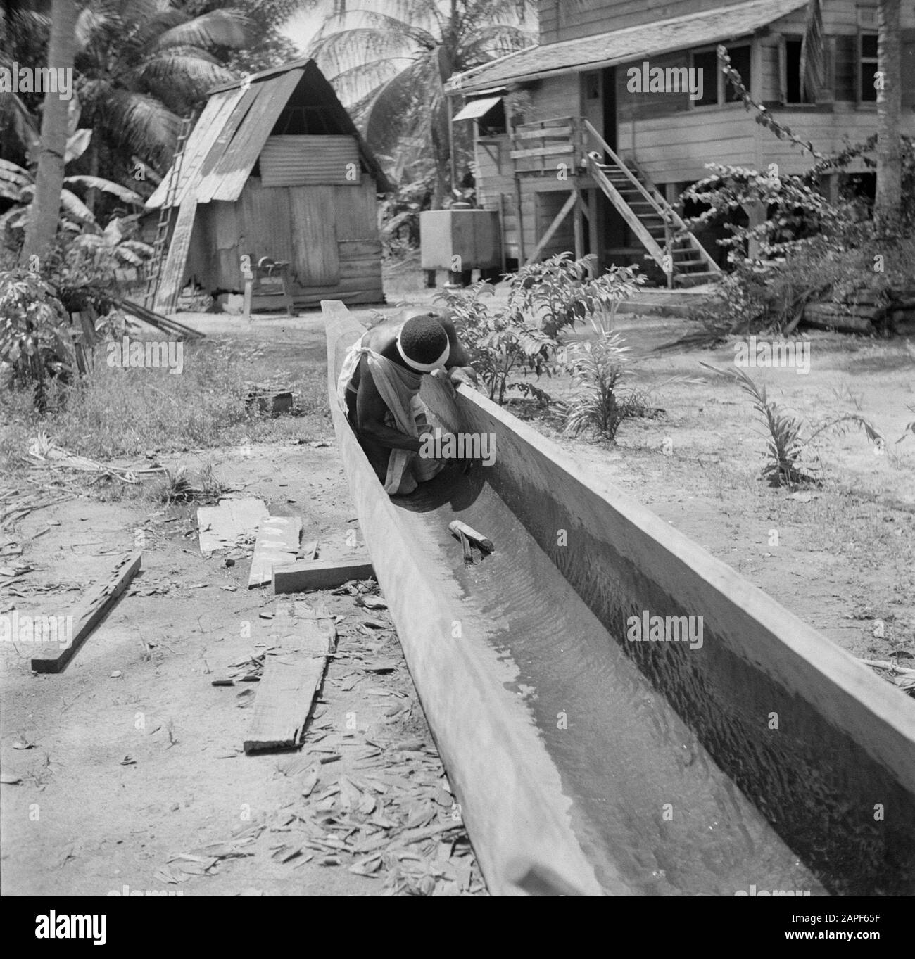 Viaggio in Suriname e Antille Olandesi Descrizione: Boslandcreool Martinus costruisce una korjaal a Langetabbetje in Suriname Data: 1947 posizione: Langatabbetje, Marowijne, Suriname Parole Chiave: Forest Land creols, ships Foto Stock