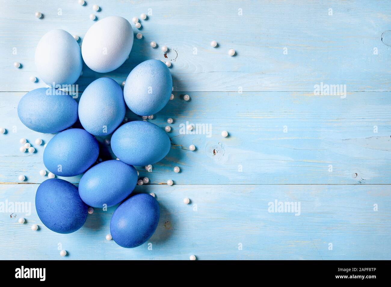 Concetto di Pasqua. Uova Ombre in colori blu su sfondo di legno blu con spazio copia per il testo. Vista dall'alto verso il basso o piatto. Colori blu classici a Pasqua 2020 Foto Stock