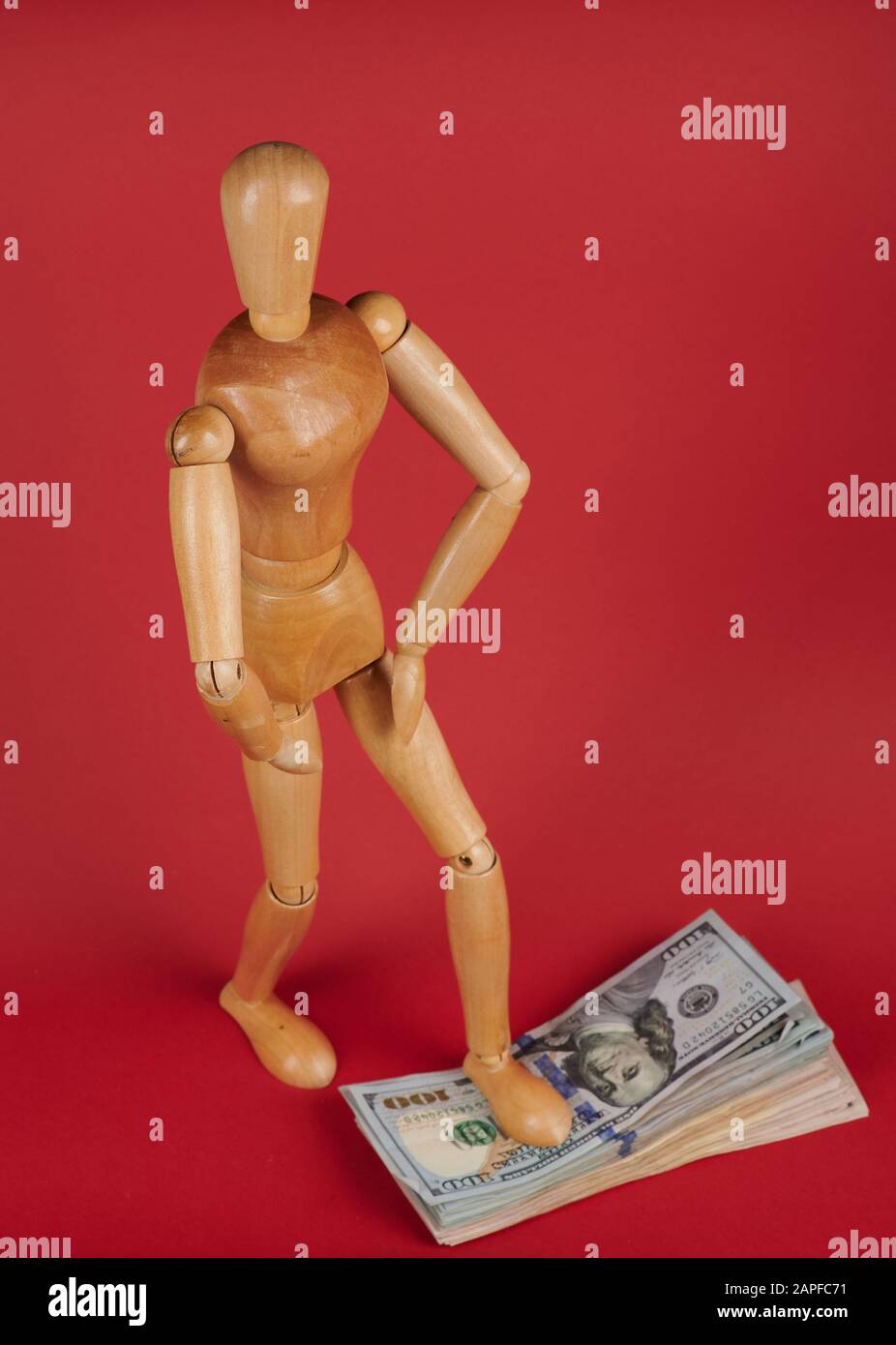 L'uomo sta sulla pila di soldi del dollaro isolato sullo sfondo rosso Foto Stock