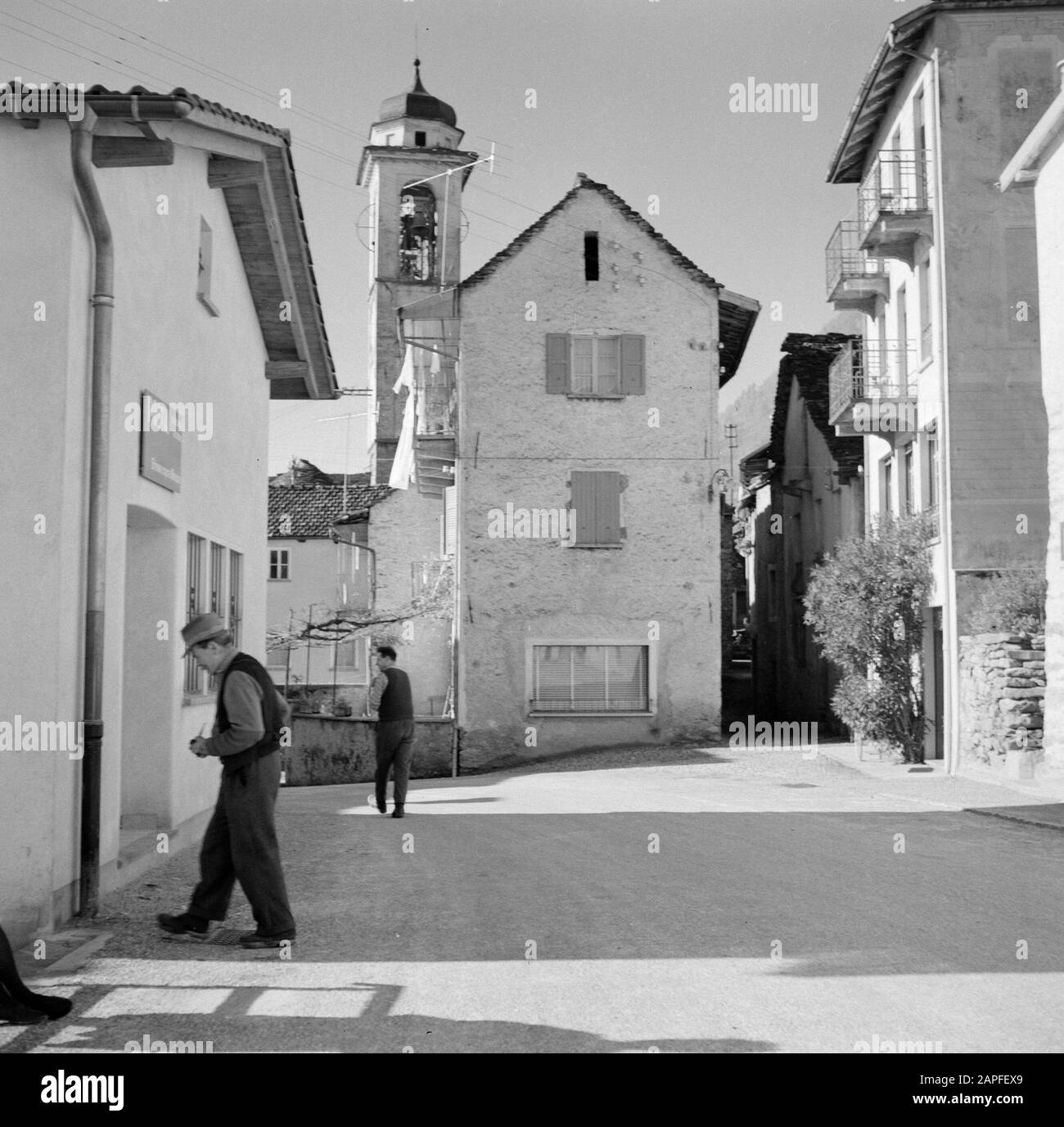 Tour lungo il lato svizzero del Lago maggiore Descrizione: Brione: Due uomini sulla piazza di fronte ad una chiesa Data: Novembre 1961 luogo: Brione sopra Minusio, Svizzera Parole Chiave: Villaggi, villaggi, edifici di chiesa, persone, piazze Foto Stock