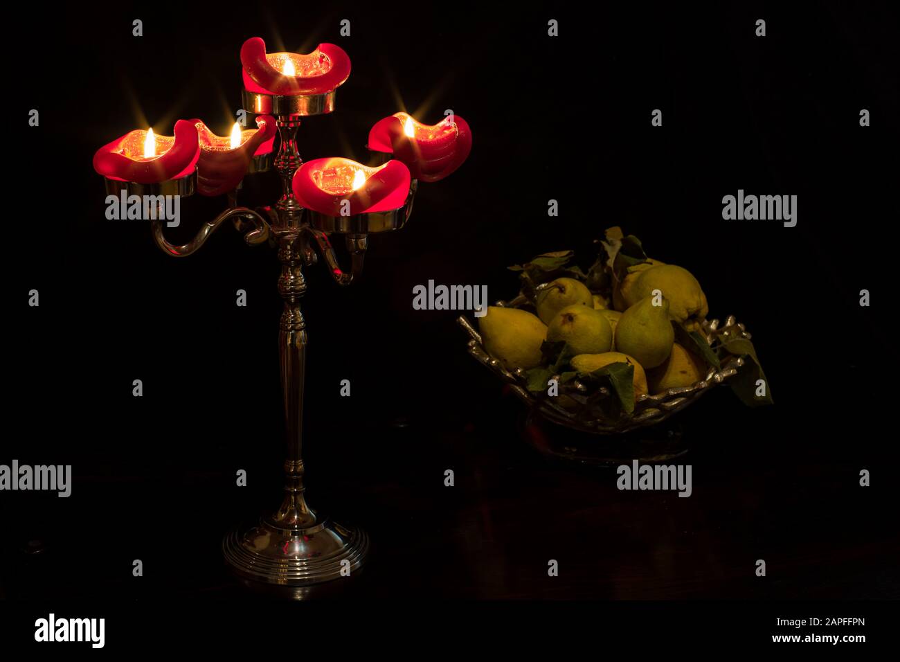 Ancora vita con un candelabro e un cesto di frutta. Foto Stock