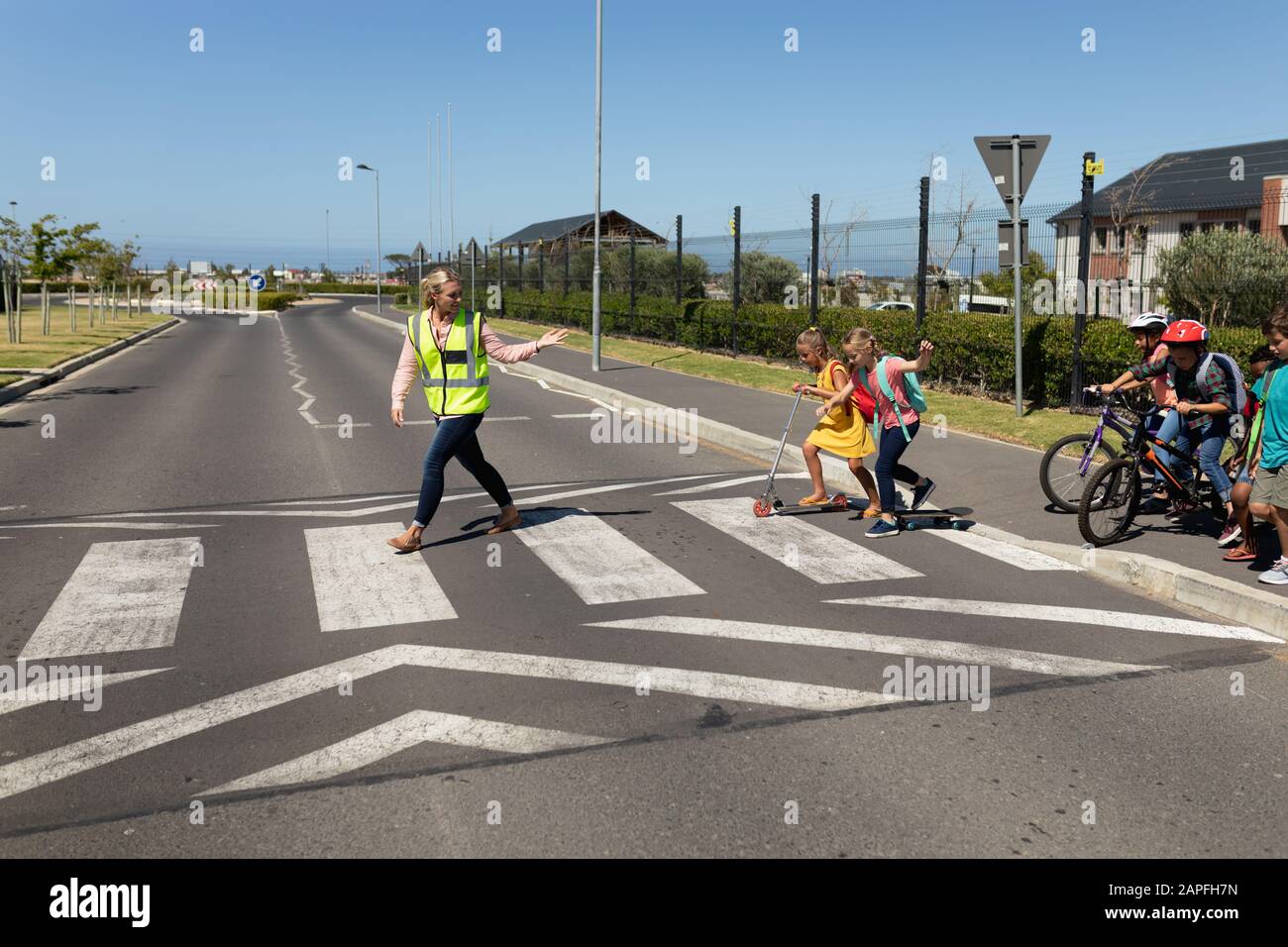Donna che indossa un giubbotto ad alta visibilità su un passaggio pedonale Foto Stock