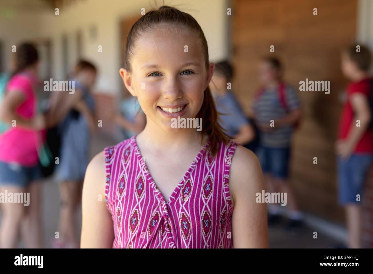 Scolaretta che si trova nel cortile della scuola elementare Foto Stock
