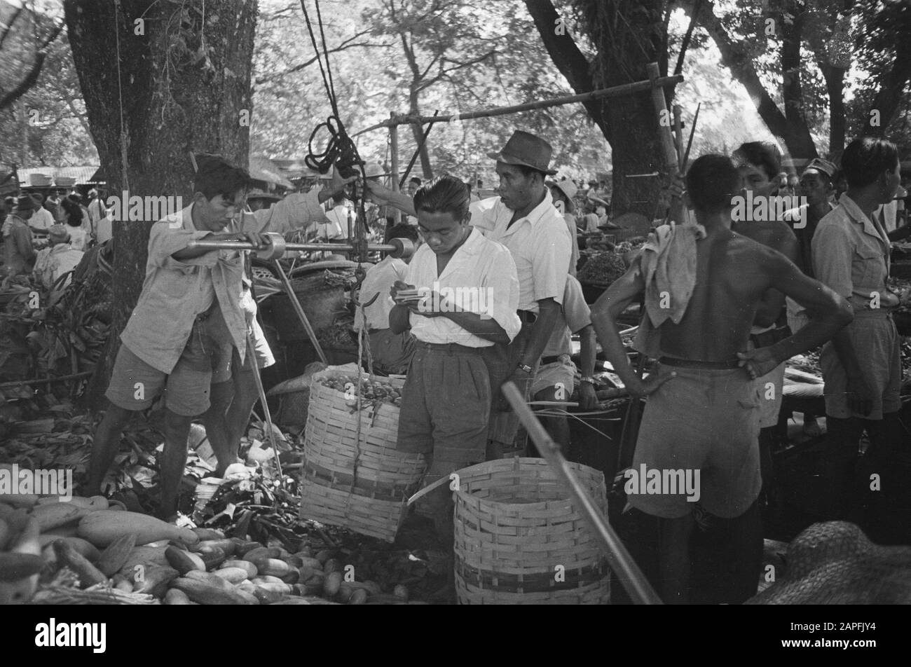 Fotografie aeree e di cura all'aperto Descrizione: Cure all'aperto. Nelle aree in cui la pace e l'ordine sono tornati, la vita indiana ha ripreso il suo corso normale. C'è un vivace traffico e il trambusto sui passar. Gli agricoltori mettono in vendita i loro prodotti lì, ora che i proventi della loro fatica non finiscono più nelle tasche dei loro signori repubblicani Data: Agosto 1947 luogo: Indonesia, Indie orientali olandesi Foto Stock