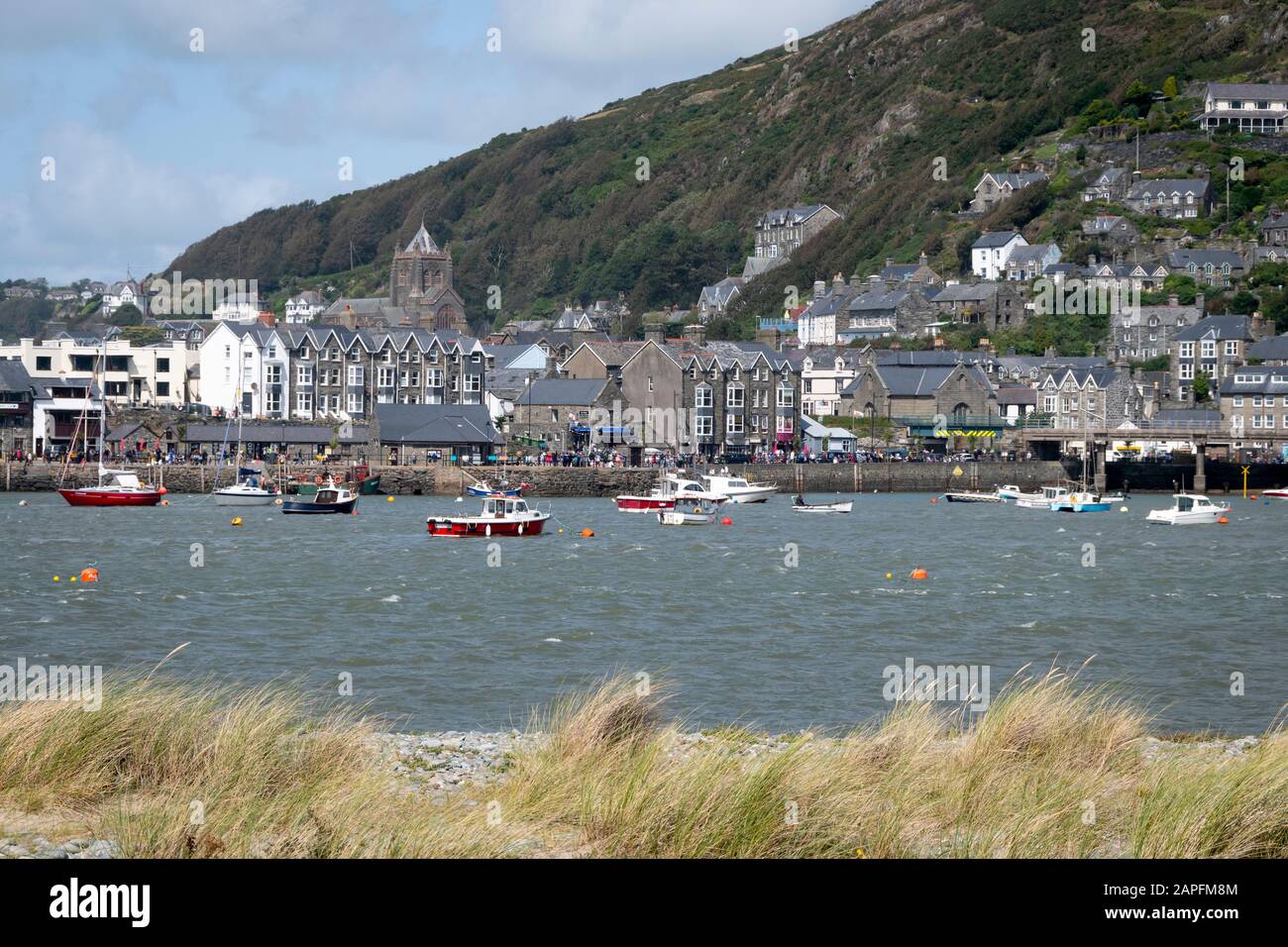 Barmouth città e porto che si affaccia attraverso l'ingresso di Afon Mawdddach, estuario di Mawddach, da Fairbourne, Galles Foto Stock