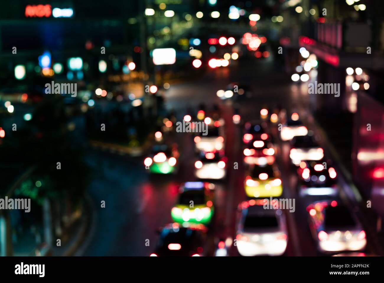 Il traffico urbano di notte è stato definito con il bokeh colorato, con sfondo Sfocato per la congestione della città, con riflessi dai negozi e dalle auto nelle vicinanze con spazio per le copie, il concetto del centro città di Metropolis Foto Stock