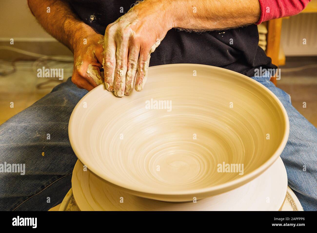 Potter lavorando sulla ruota del vasaio con argilla grezza con le mani, facendo nuova ciotola, concetto di piccola arte di affari Foto Stock
