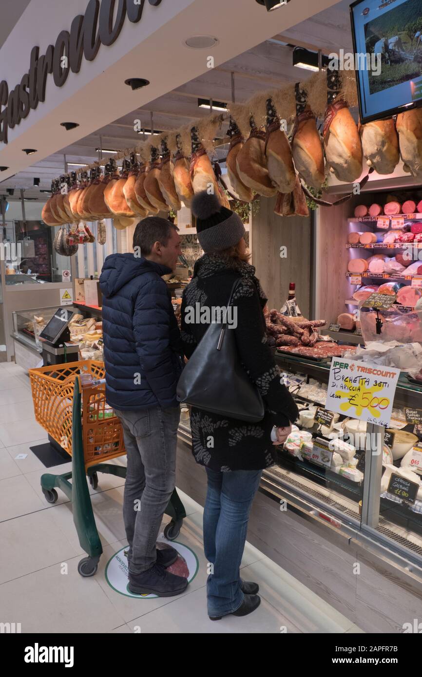 Coppia in un banco Delicatessen all'interno di un supermercato locale in Italia Foto Stock