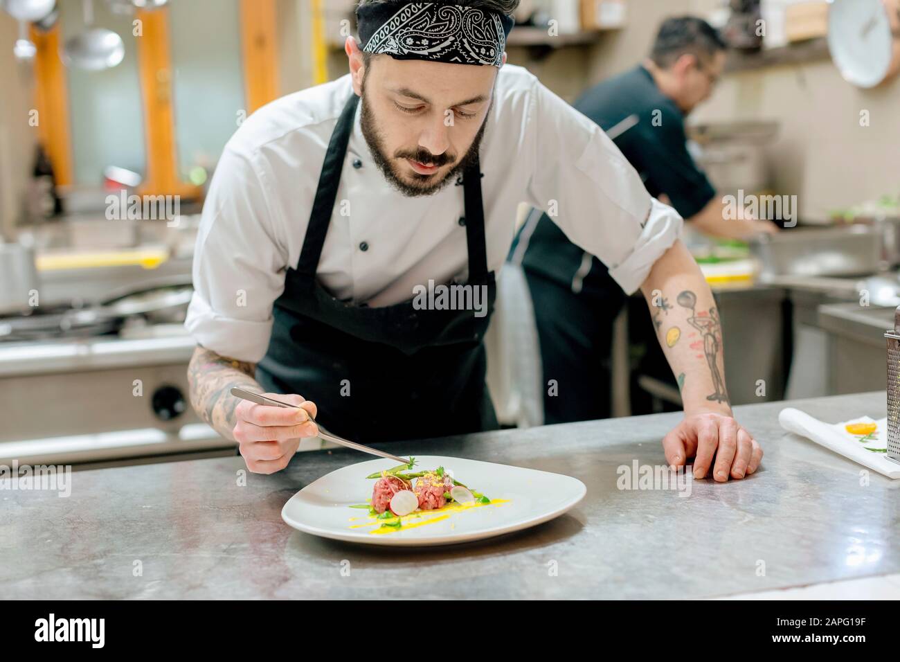 Lo chef prepara piatti di carne cruda in cucina Foto Stock