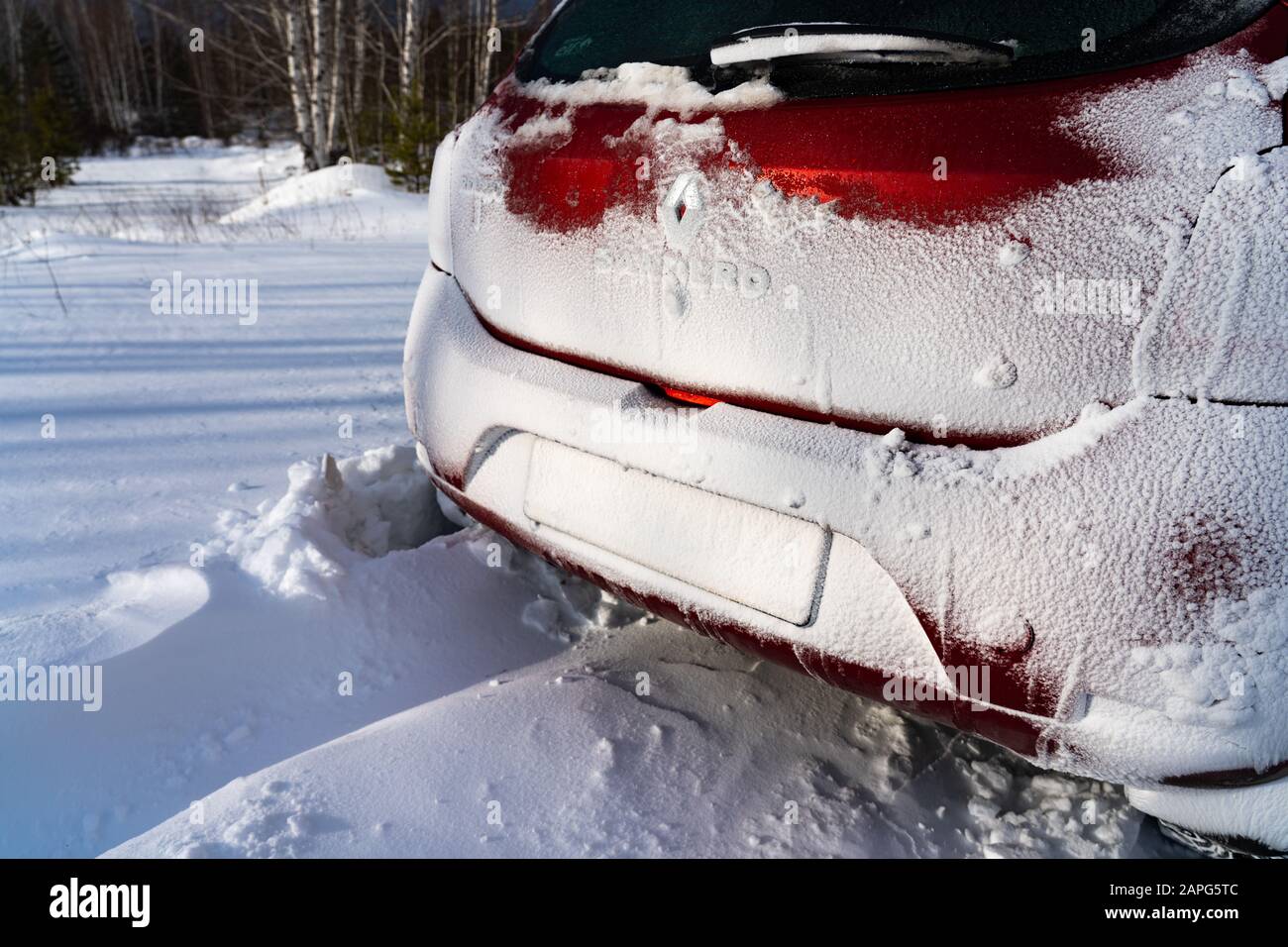 Ekaterinburg, Russia - Gennaio 2020. La parte posteriore di una vettura rossa Renault Sandero 2 è coperta di neve. Viaggi estremi sulle strade innevate della Russia. Primo piano Foto Stock