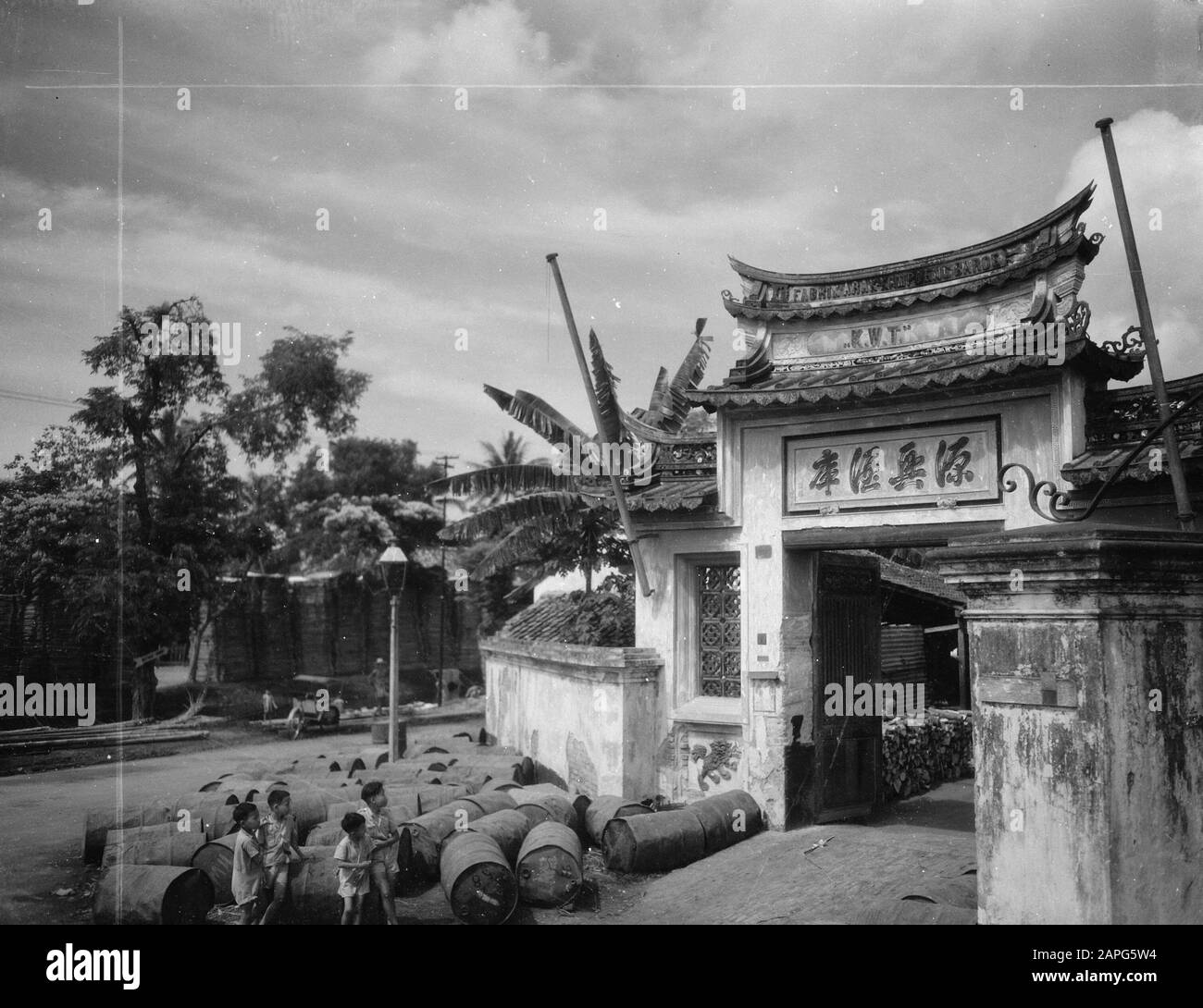 Lower Town for Welfare Calendar Description: Chinese Gate nella Città Bassa di Batavia, di fronte a loro si trovano barili di petrolio Data: 23 ottobre 1947 posizione: Batavia, Indonesia, Jakarta, Indie orientali olandesi Foto Stock