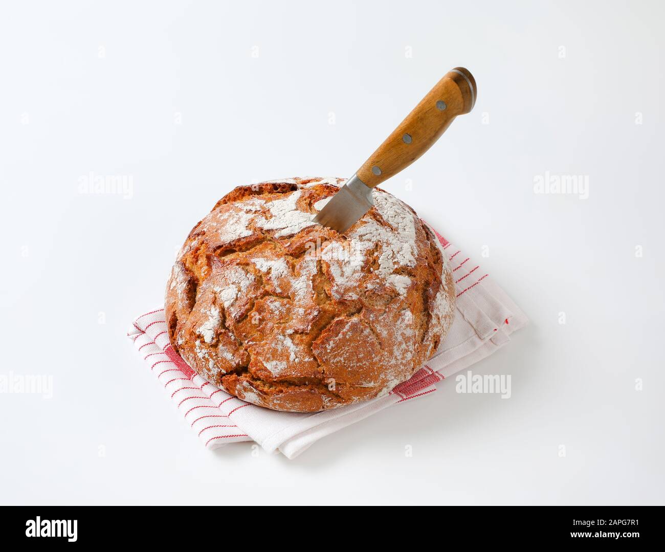 Pagnotta di pane rustico con un coltello attaccato in esso Foto Stock