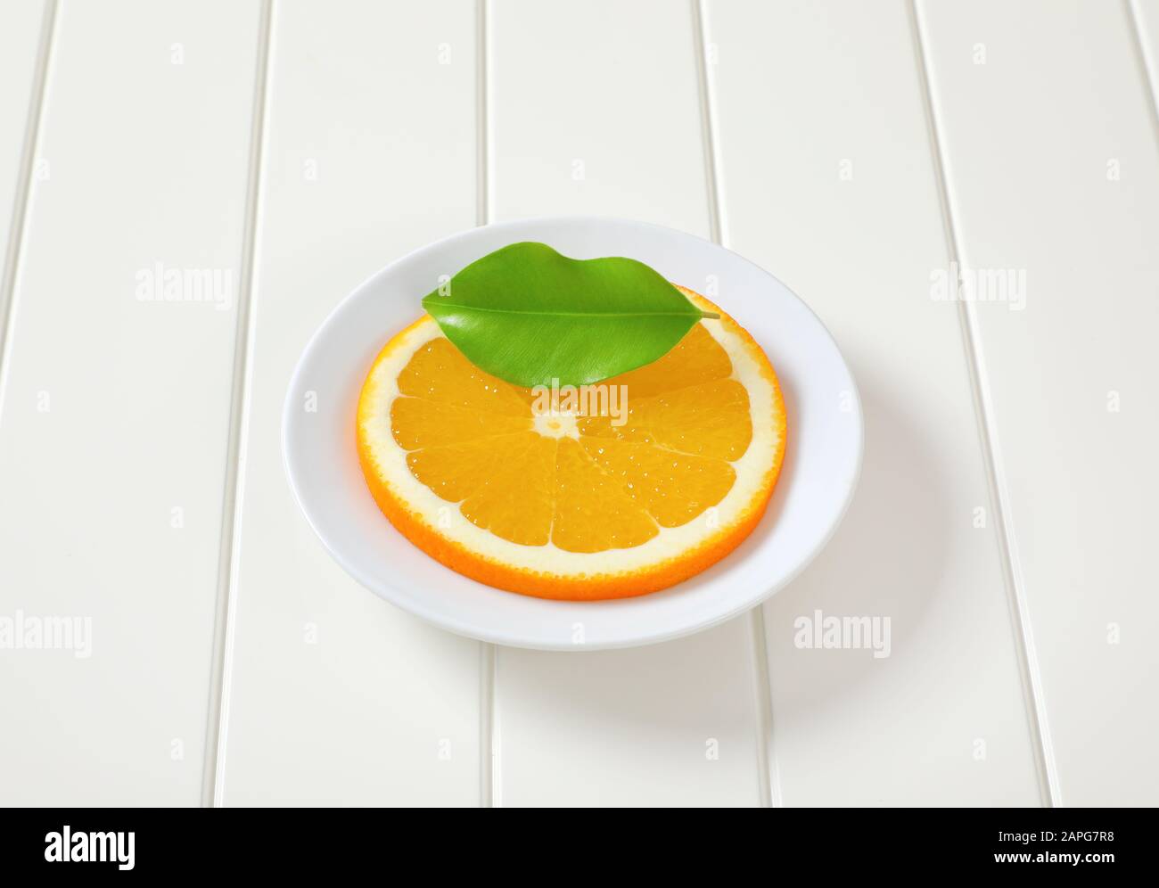 Sottile strato di arancione fresco su piastra bianca Foto Stock