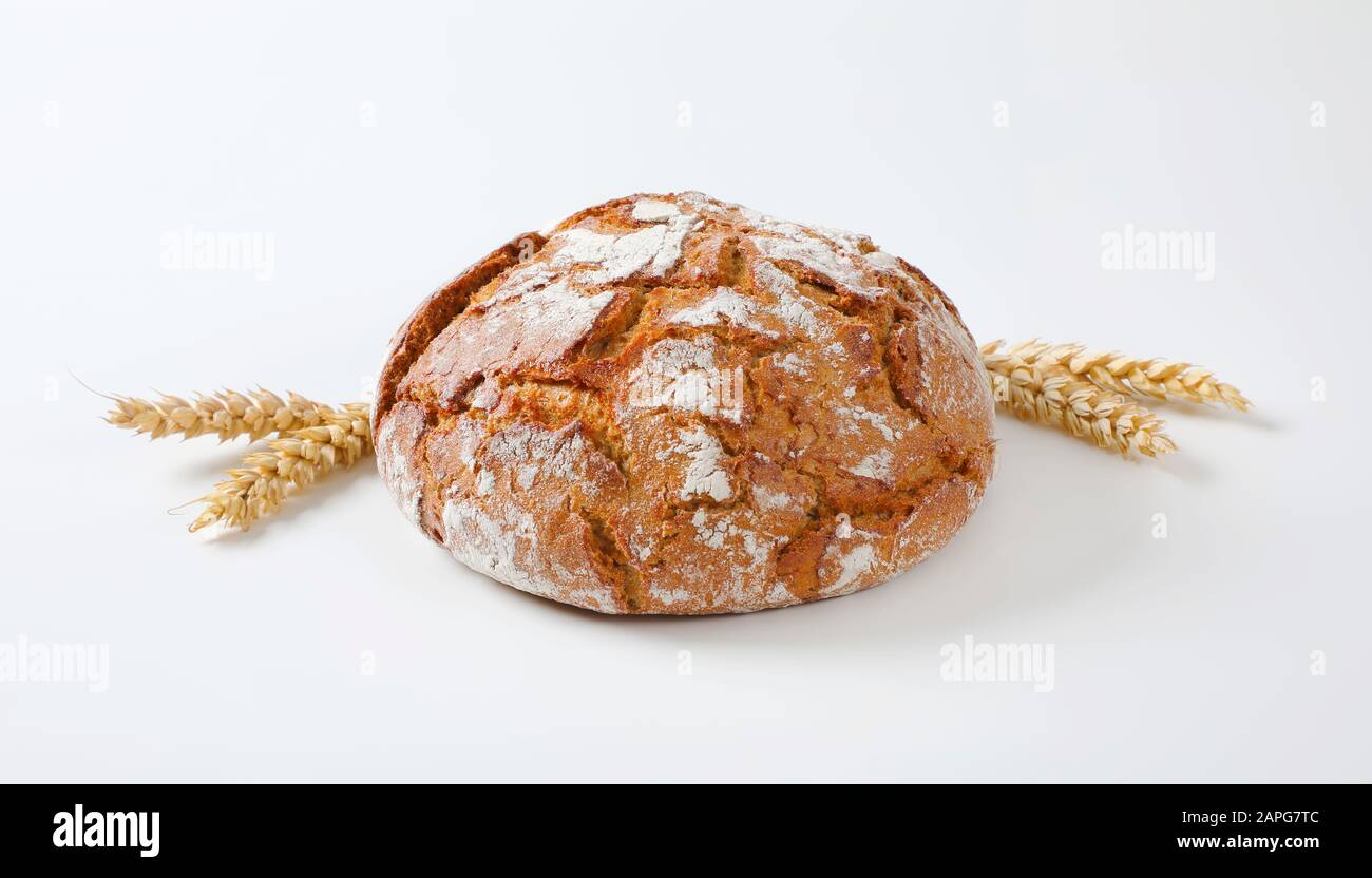 Pagnotta di pane rustico e spighe di grano Foto Stock