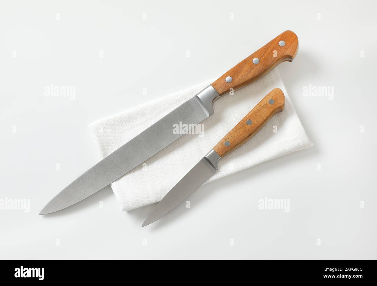 Coltello da cucina e coltello da taglio su tovagliolo bianco Foto Stock
