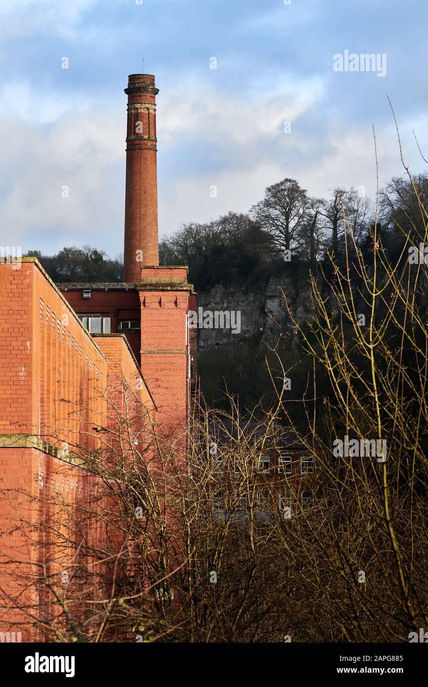 Masson Mill di Sir Richard Arkwright, un mulino per la produzione di cotone costruito in mattoni rossi arancioni nel 18th secolo accanto al fiume Derwent a Matlock Bat Foto Stock