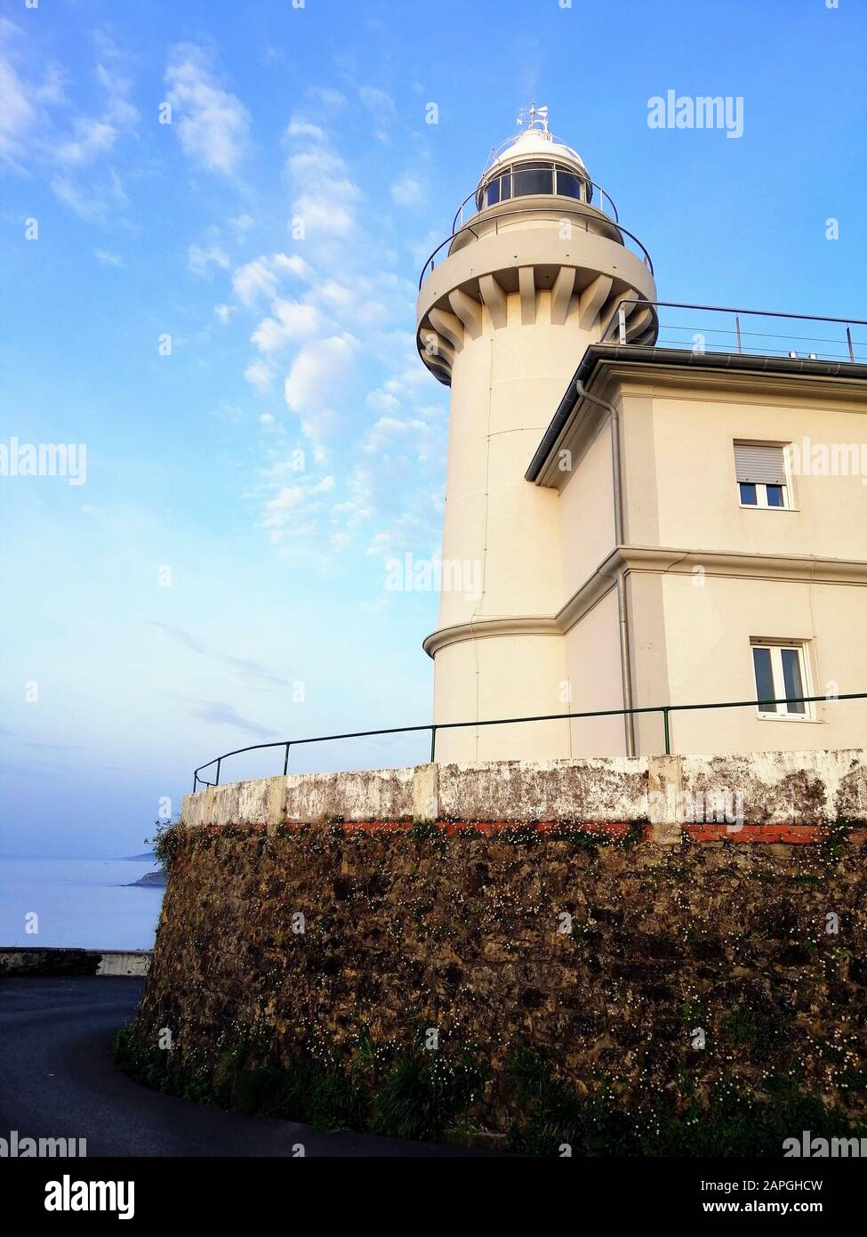 Immagine verticale di un faro che tocca il cielo limpido sulla spiaggia di San Sebastian, Spagna Foto Stock
