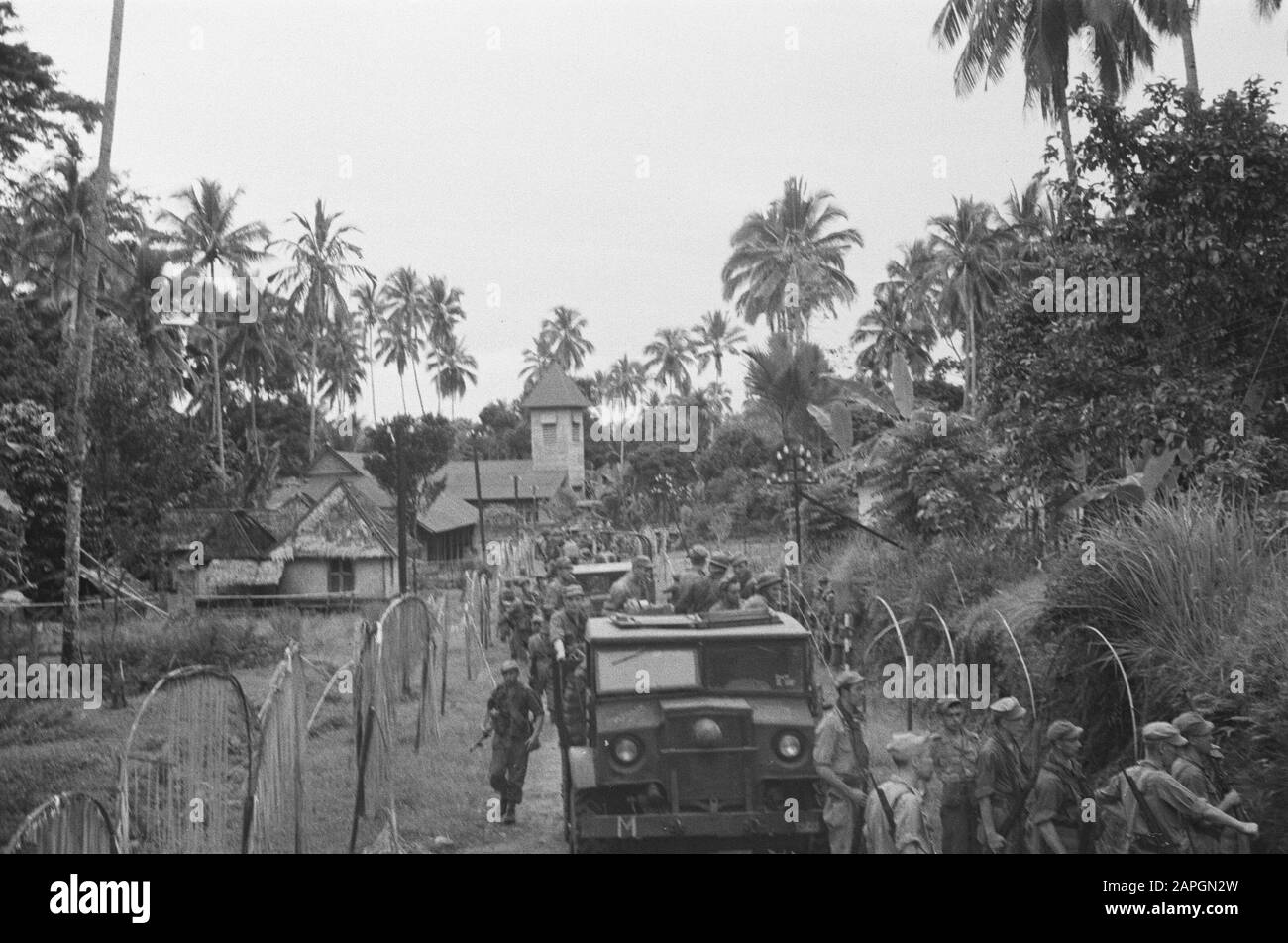 Medan Descrizione: Colonna veicoli militari con fanti in un villaggio. La strada è fiancheggiata da decorazioni. Sul retro di una chiesa? Date: 1947 Location: Indonesia, Dutch East Indies, Sumatra Foto Stock