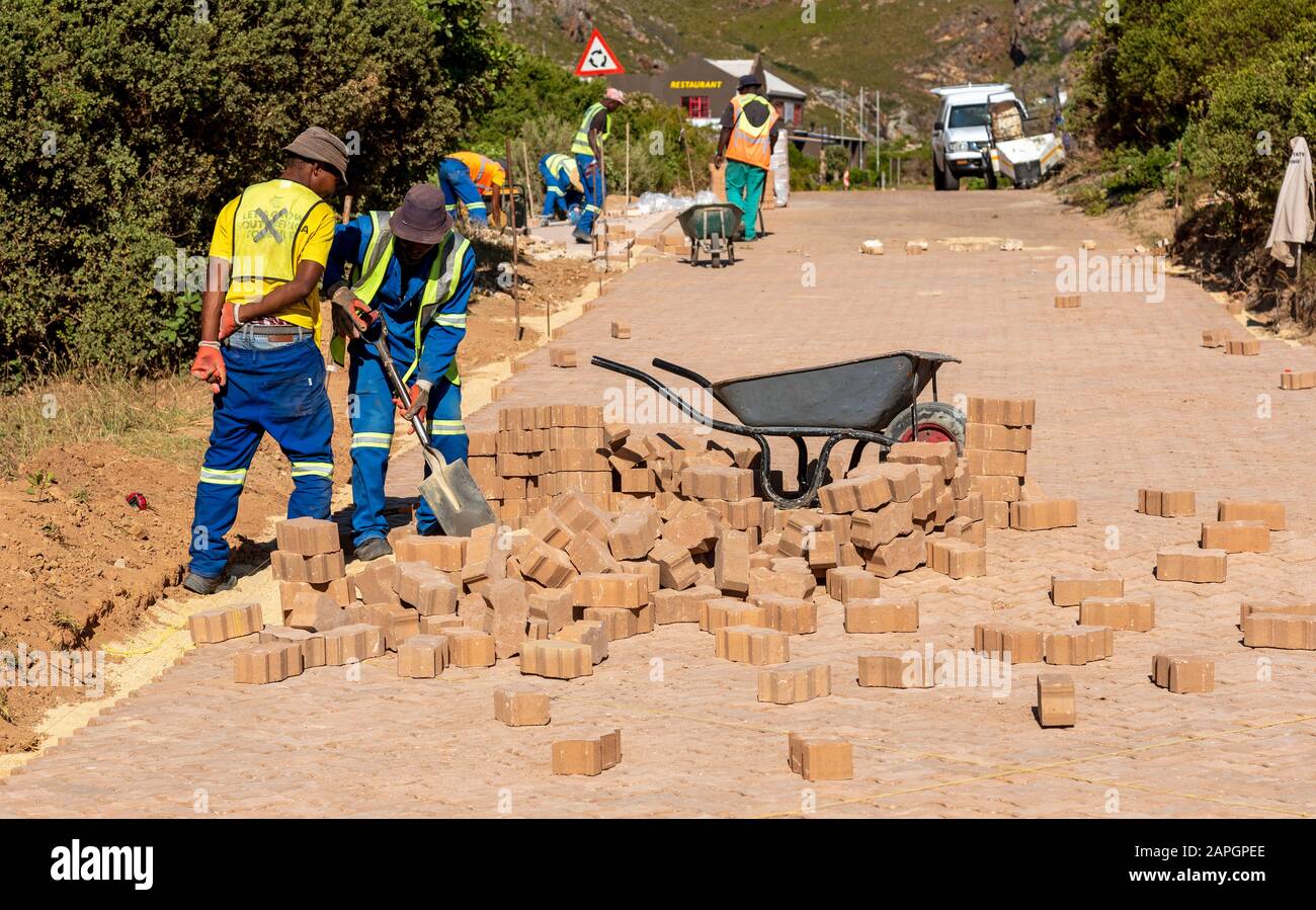Rooiels, Capo Occidentale, Sud Africa. Dicembre 2019. Lavoratori che posano una strada di mattoni nella piccola frazione di Rooiels. Foto Stock