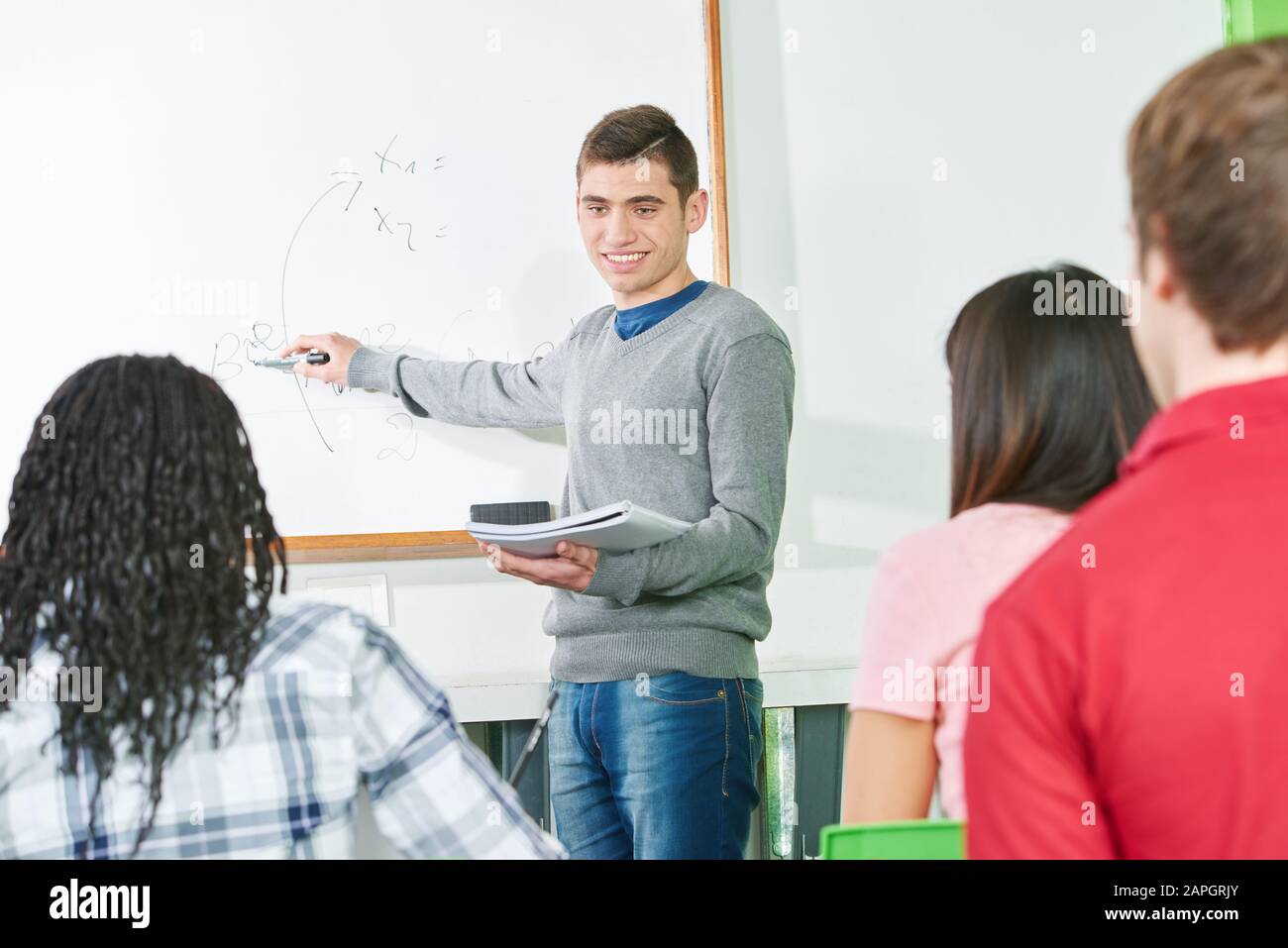 Il giovane insegnante presso l'ufficio legale a scuola dà lezioni Foto Stock