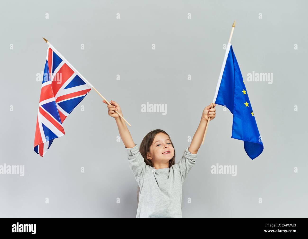 Bambino che batte bandiera britannica e bandiera dell'Unione europea Foto Stock