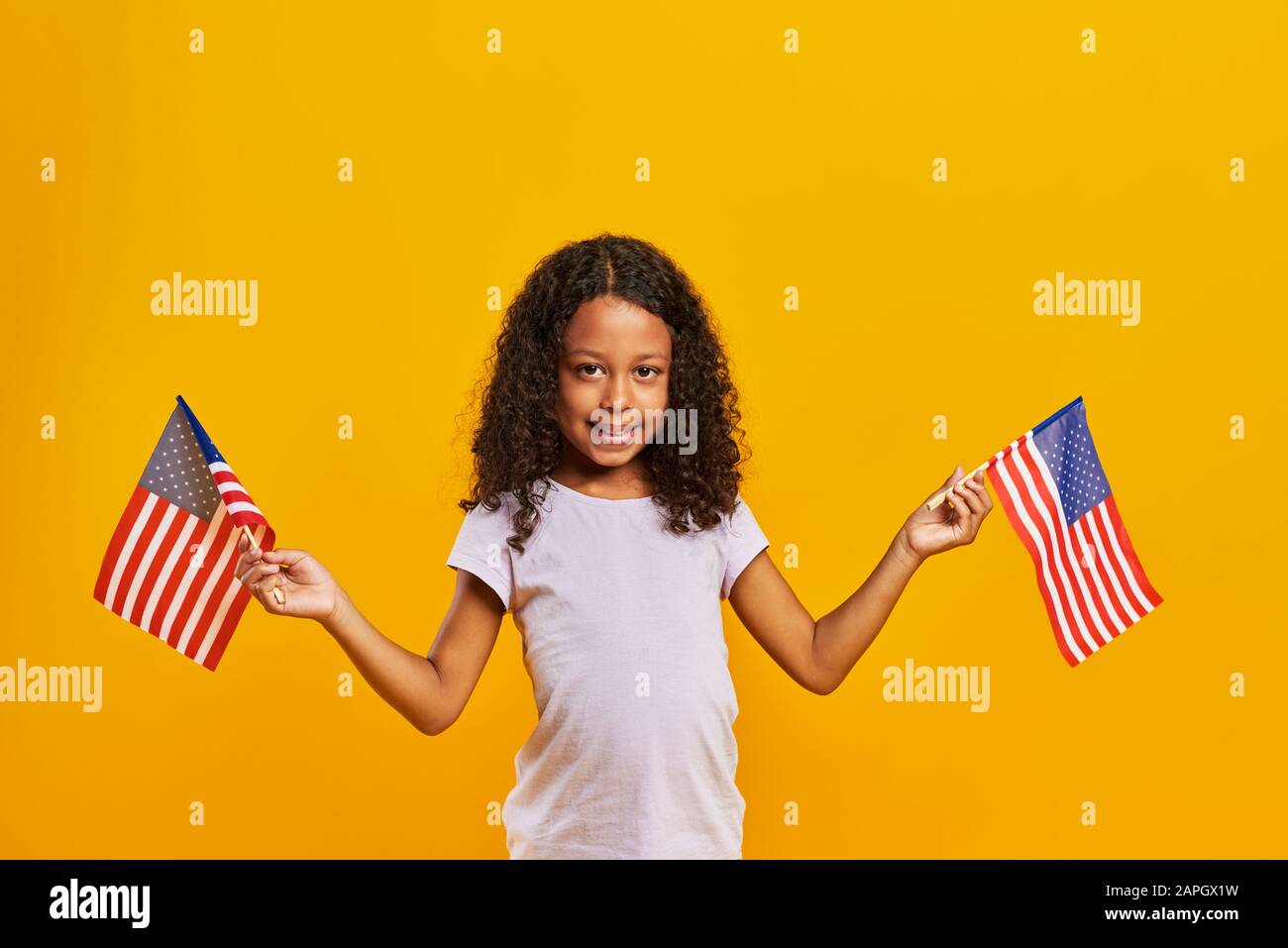 Ragazza africana che sventola bandiere americane Foto Stock