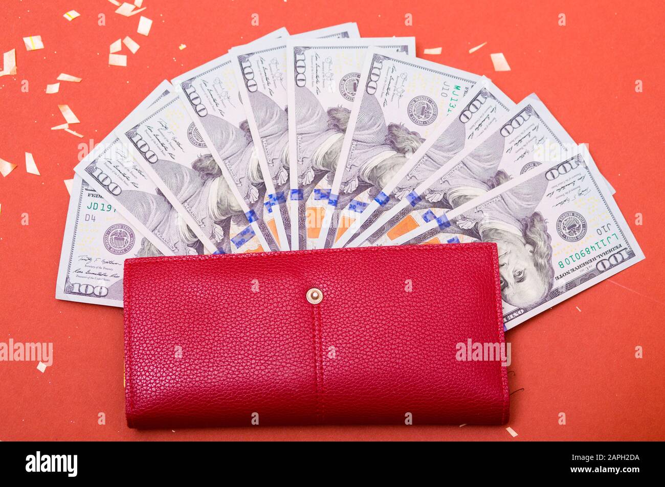 Curency americana del centinaio del dollaro, banconote nel portafoglio rosso. Ricchezza, risparmio di denaro, abbondanza. Spazio per il testo su sfondo rosso. Foto Stock