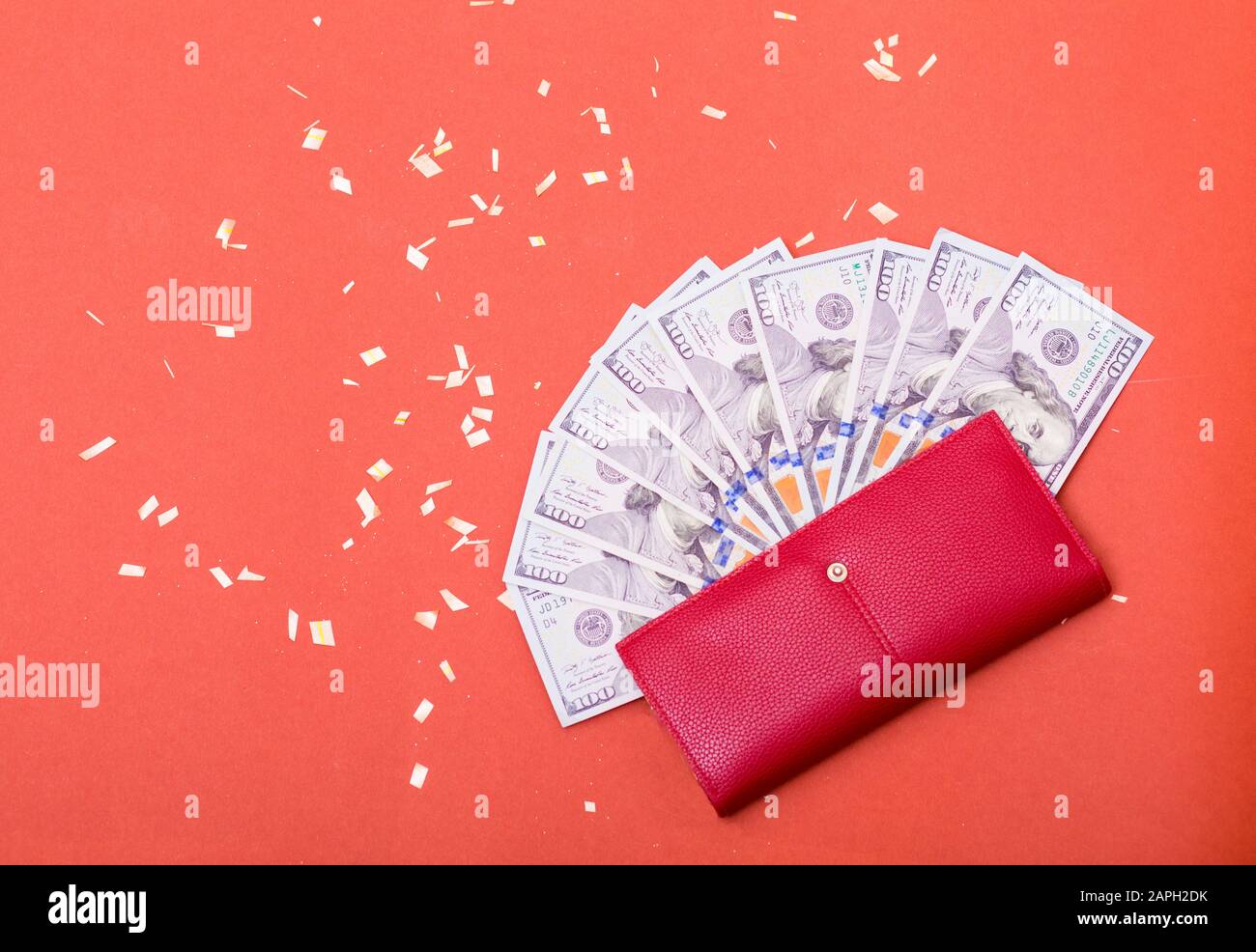 Curency americana del centinaio del dollaro, banconote nel portafoglio rosso. Ricchezza, risparmio di denaro, abbondanza. Spazio per il testo su sfondo rosso. Foto Stock