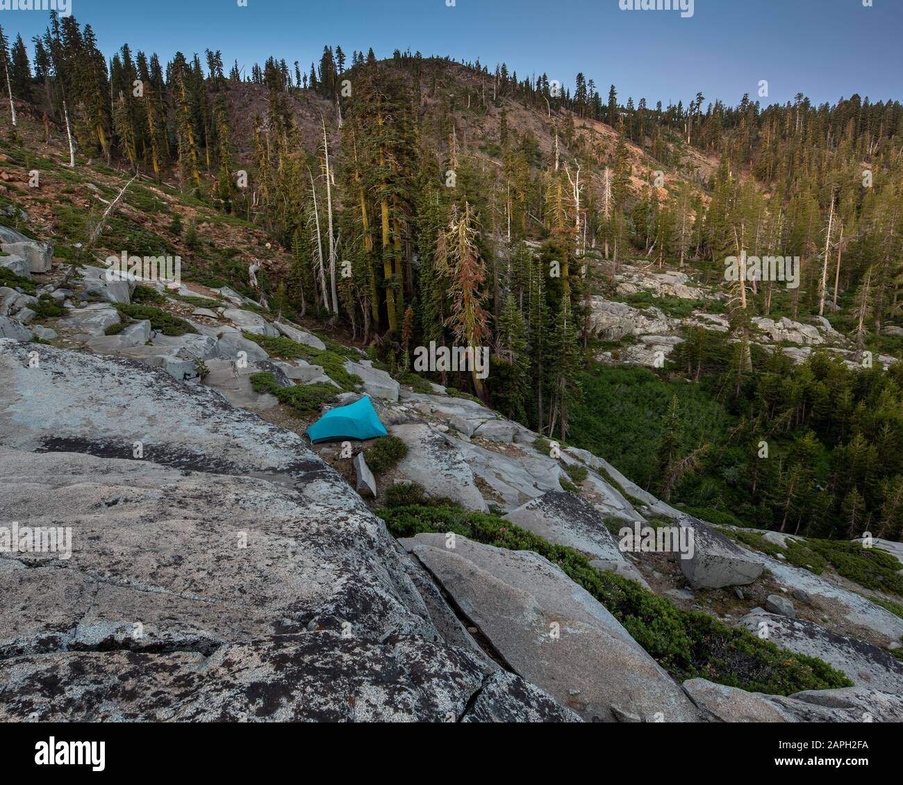 Tenda blu situata nella Sierra Nevada vicino al lago Island, California, caratterizzata da un terreno roccioso accidentato, per illustrare il concetto di avventura nel ou Foto Stock