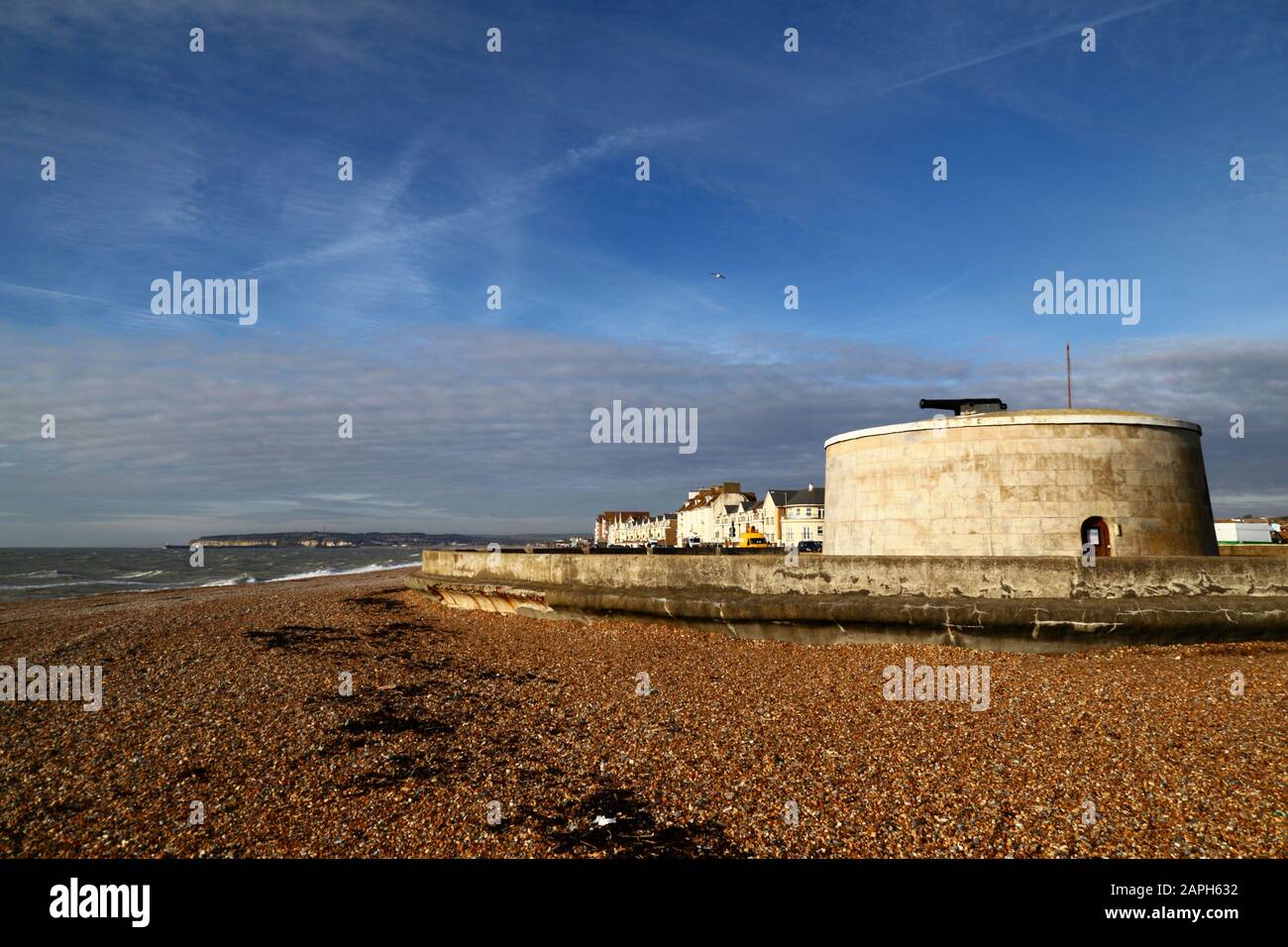 Martello Tower numero 74and edifici sul fronte mare in un pomeriggio invernale, Seaford, East Sussex, Inghilterra Foto Stock