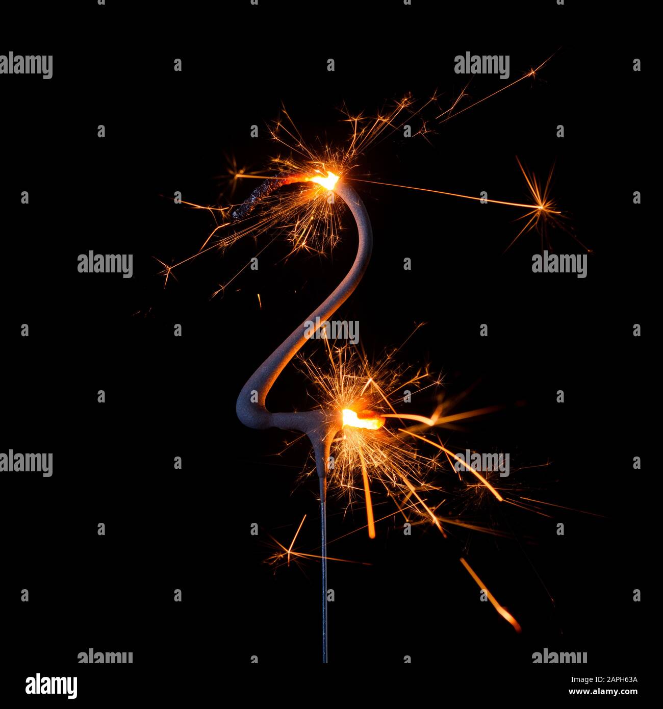 Brillante sparkler bruciante a forma di numero due, cifra 2, isolato su sfondo nero. Foto Stock