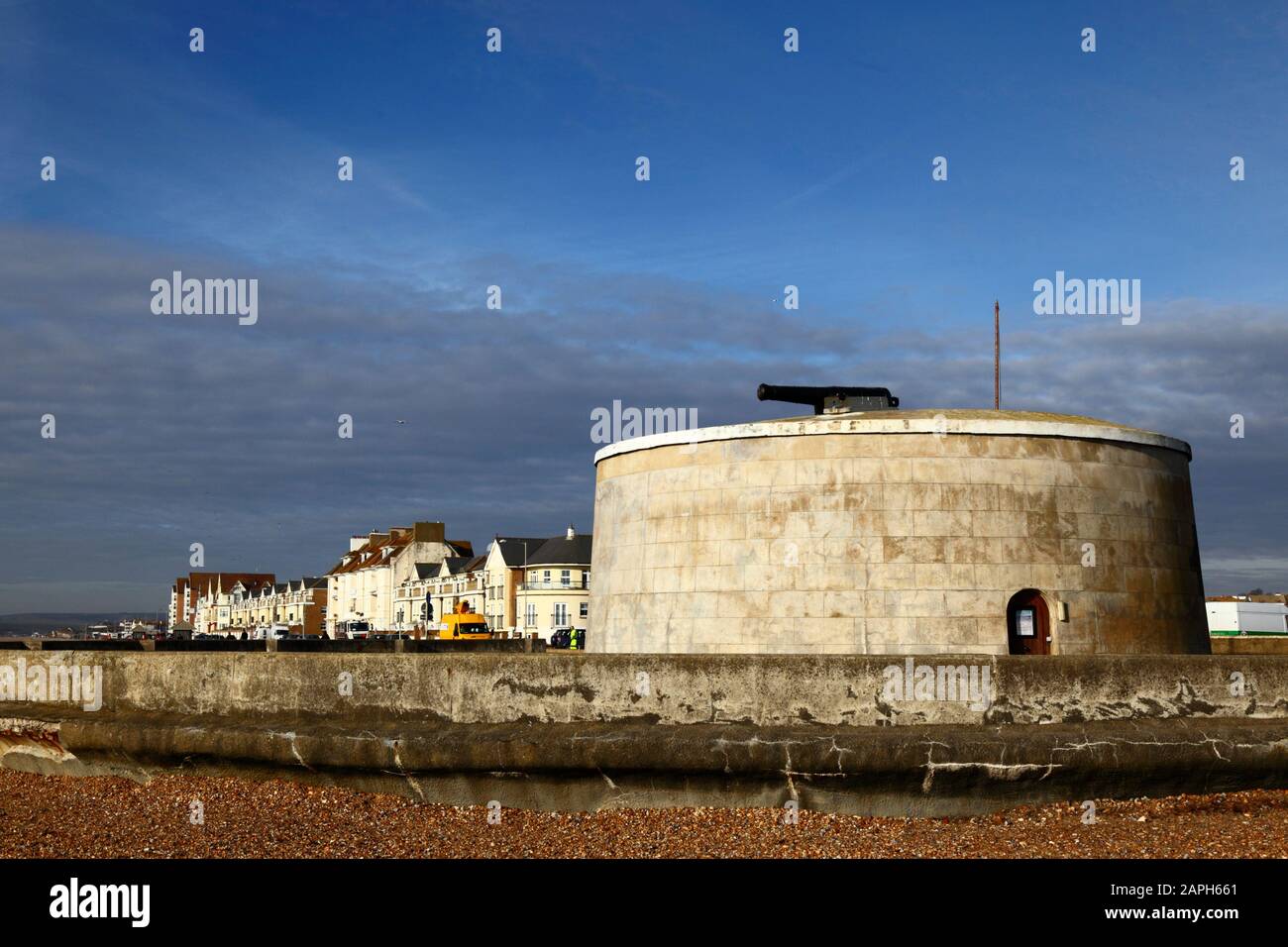 Martello Tower numero 74and edifici sul fronte mare in un pomeriggio invernale, Seaford, East Sussex, Inghilterra Foto Stock