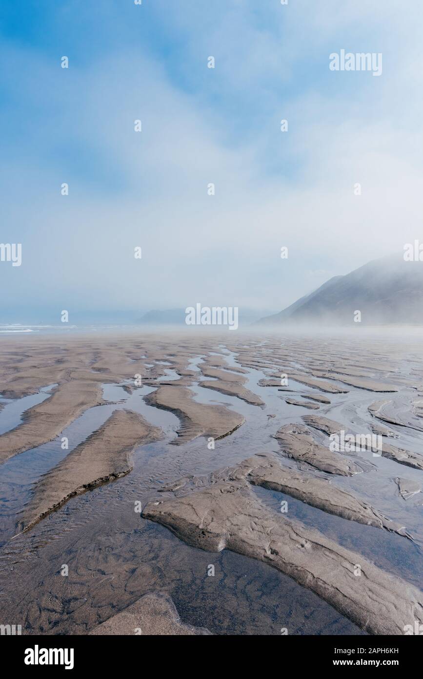 Bellissima spiaggia di nebbia con pozzanghere e ruscelli Foto Stock