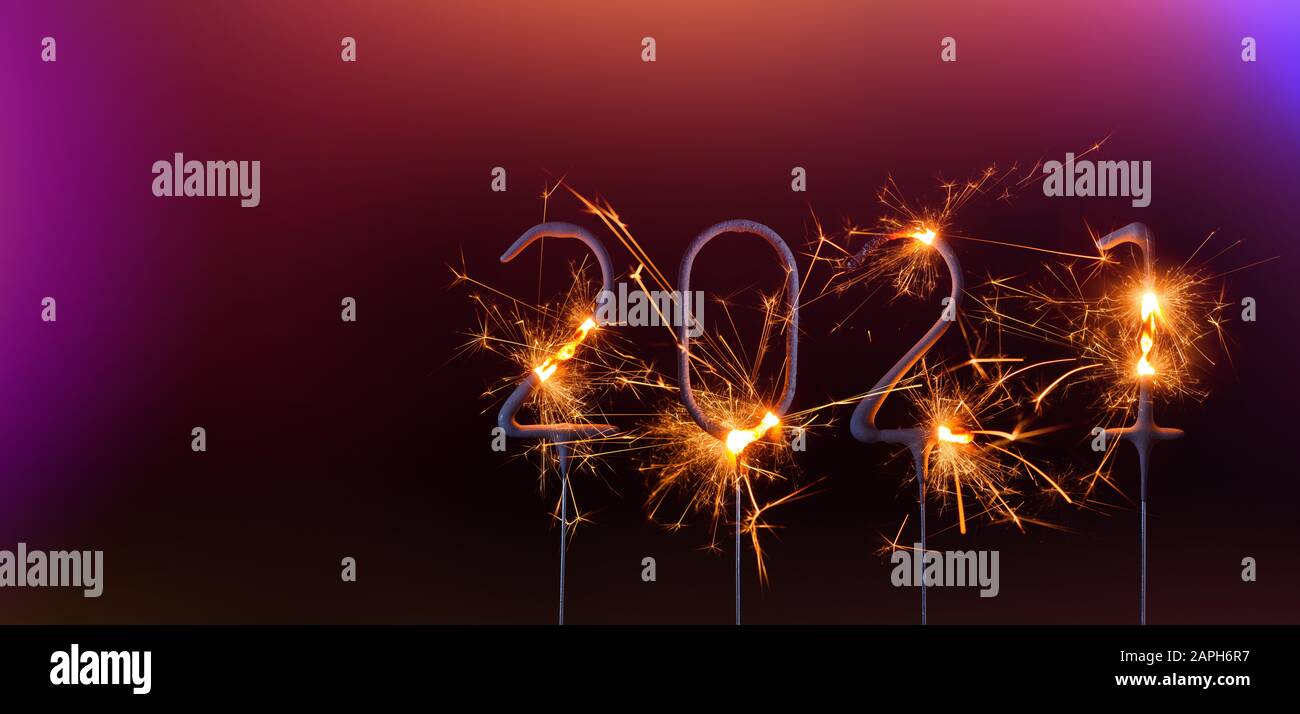 Modello banner felice anno nuovo 2021. Cifre dell'anno 2021 realizzate da sparklers brucianti isolati su sfondo nero. Foto Stock