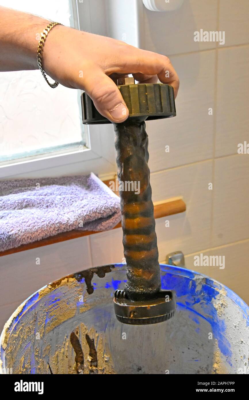 Il filtro della caldaia magnetica del riscaldamento centrale interno è stato rimosso durante la manutenzione annuale prima della pulizia dei fanghi di metalli ferrosi dai radiatori Inghilterra UK Foto Stock