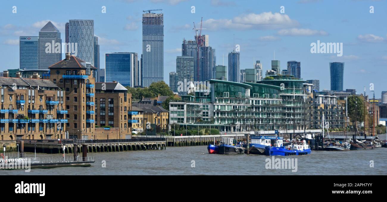 Paesaggio urbano panoramico lungo il fiume di edificio di appartamenti sul lato dell'acqua e dello skyline di Canary Wharf grattacielo costruzione sito East End London Inghilterra UK Foto Stock