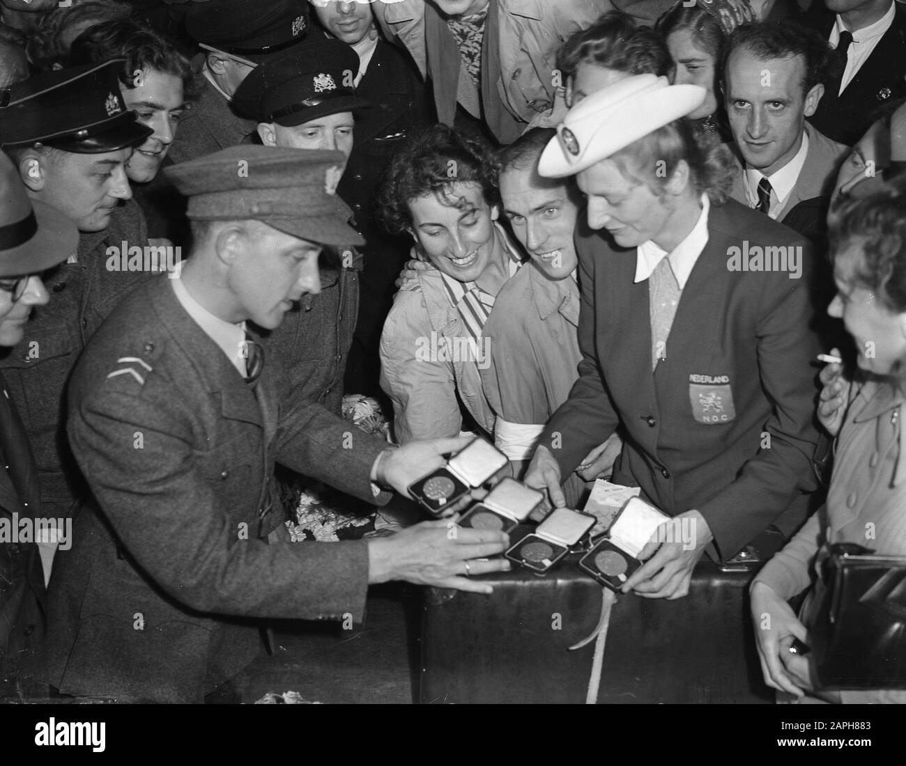 L'ufficiale doganale di Fanny Blankers-Koen con le medaglie d'oro Data: 9 agosto 1948 luogo: Angolo d'Olanda Parole Chiave: Atleti, costumi, medaglie Nome personale: Blankers-Koen, Fanny Foto Stock
