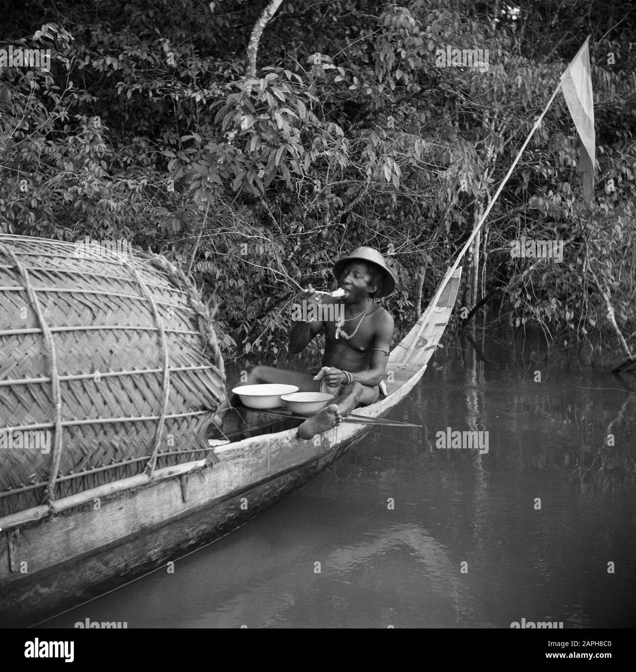 Viaggio in Suriname e Antille Olandesi Descrizione: La foresta creool Mongoto mangiare nel suo corallo a Langetabbetje Annotazione: Il pasto consiste di riso o manioca diluito con acqua di fiume Data: 1947 posizione: Langatabbetje, Marowijne, Suriname Parole Chiave: Popolazione indigena, pasti, fiumi, navi Foto Stock