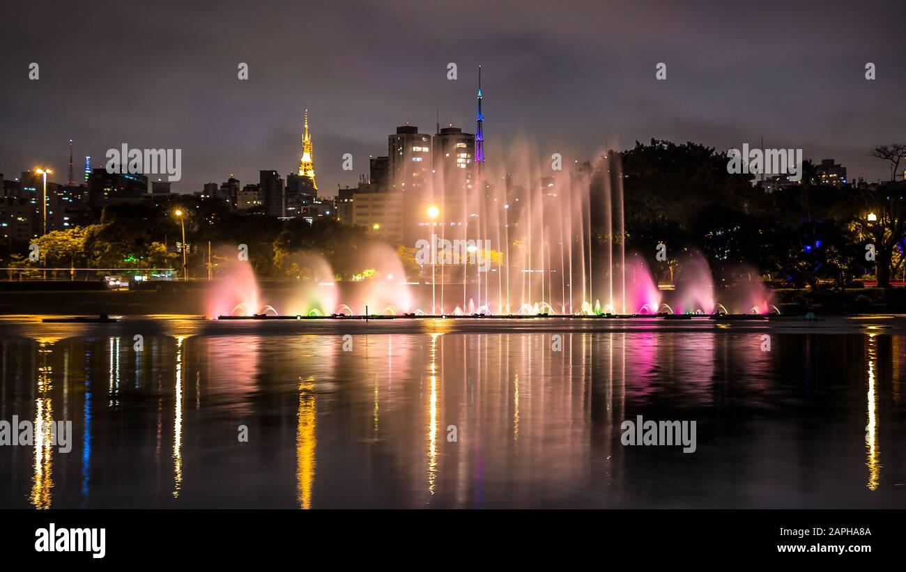 Parco Illuminato Di Ibirapuera Di Notte. Grattacieli Moderni, Reflection On The Lake E Floating Fountain. Getti D'Acqua Elevati, Miracle Lights Of Metropolis Foto Stock